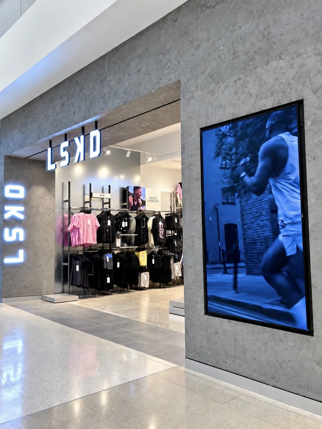 LSKD Robina shopfront on the Gold Coast with textured concrete, illuminated signage and a cobalt blue digital display.