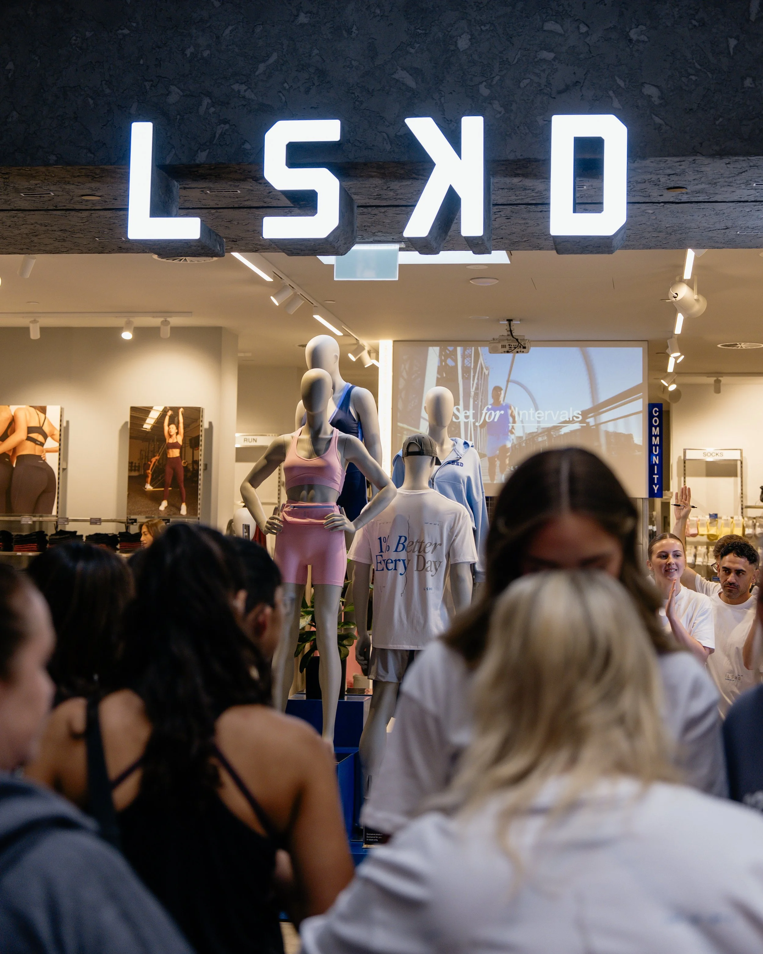 Visitors entering LSKD Karrinyup beneath illuminated storefront signage on opening day.