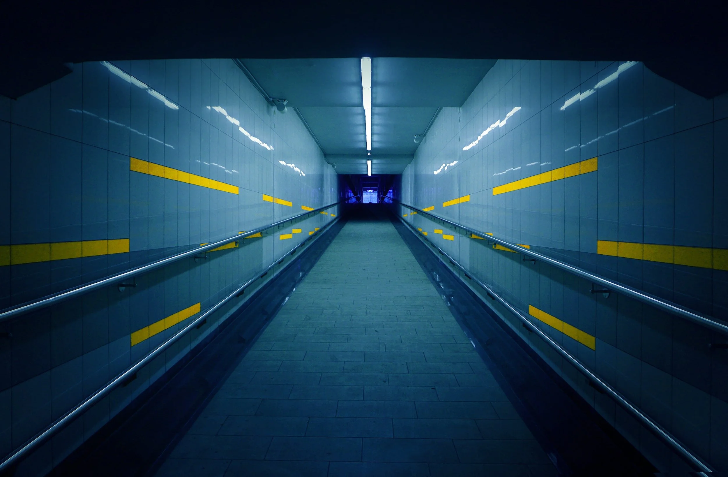Underground tunnel with tiled walls and yellow markings