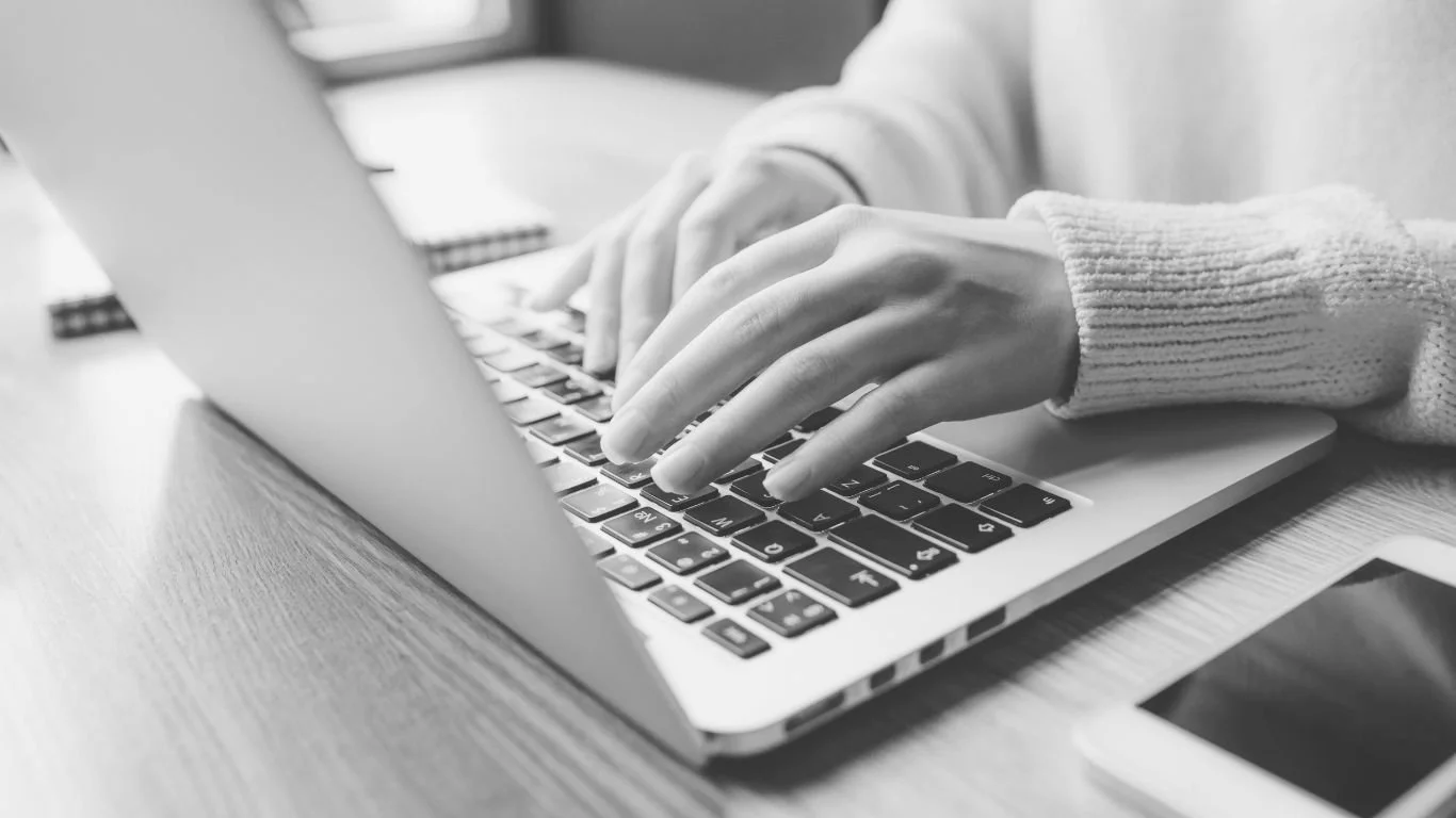 Handen die typen op een laptop