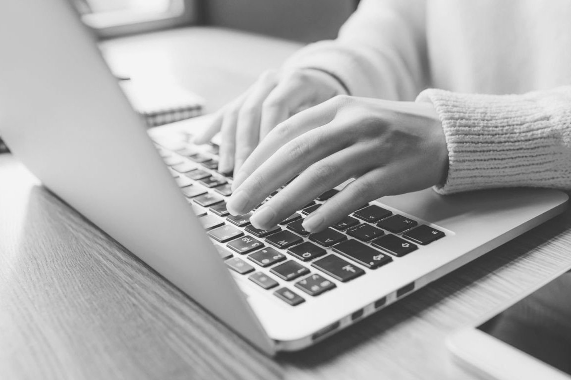 Vrouwenhanden op een laptop.