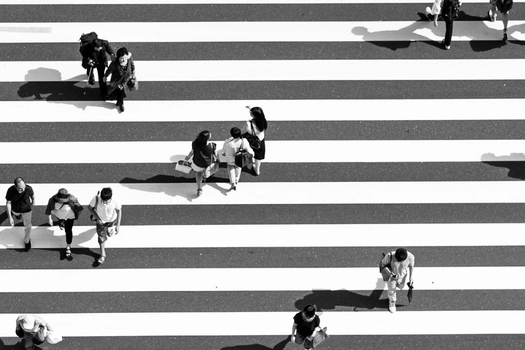 Mensen gezien van bovenaf die een zebrapad oversteken.