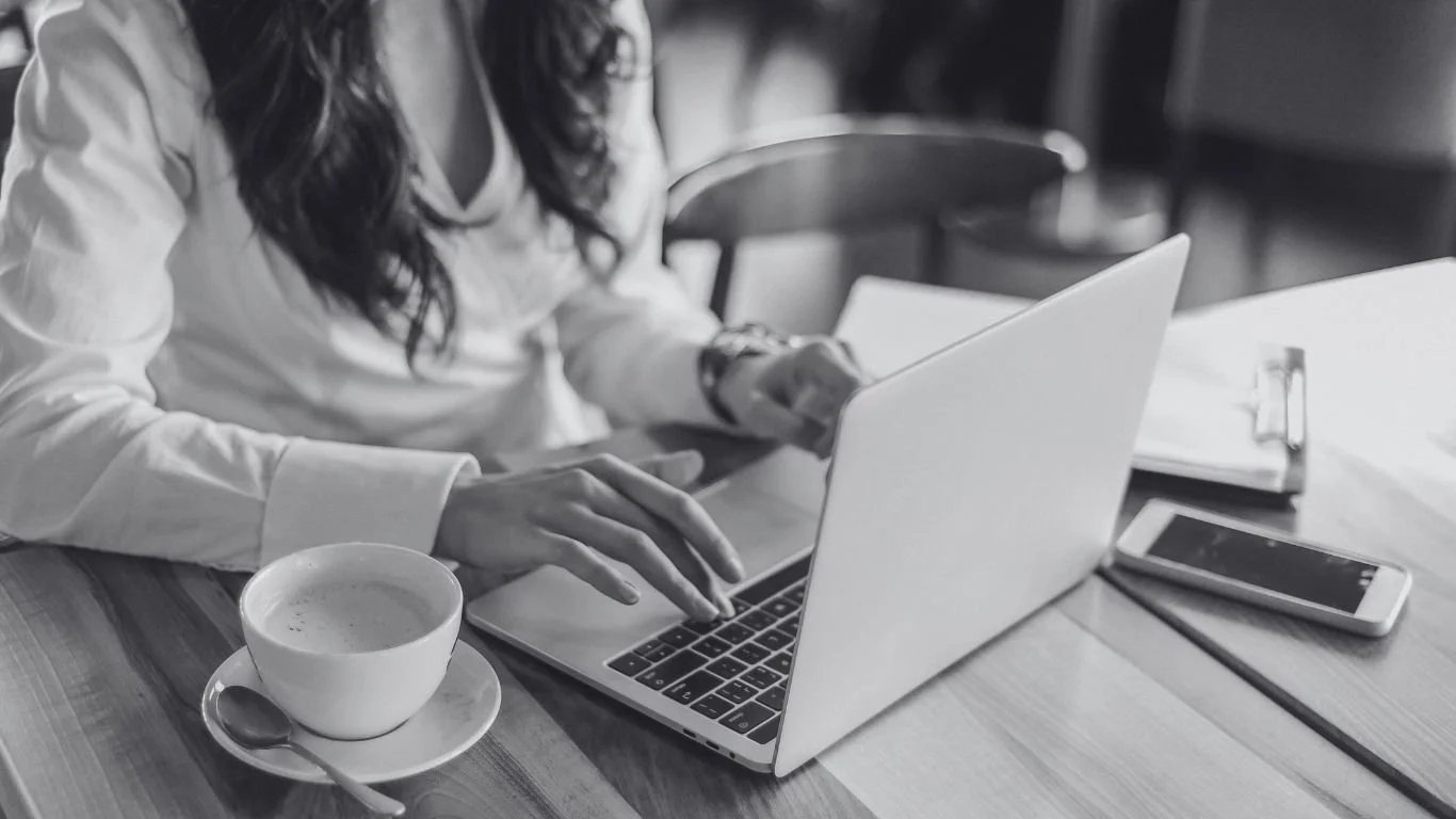 Handen van een vrouw die typt op een laptop