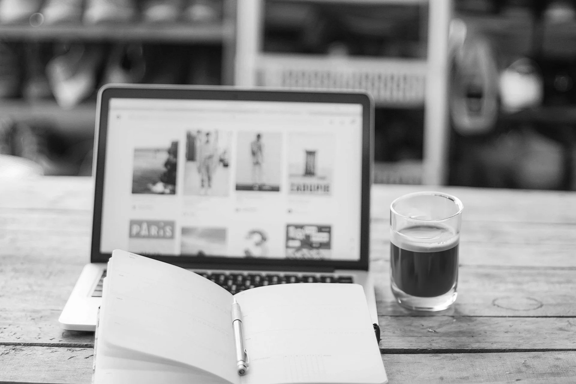 Een werkplek met een laptop, een kop koffie en een notitieblok.