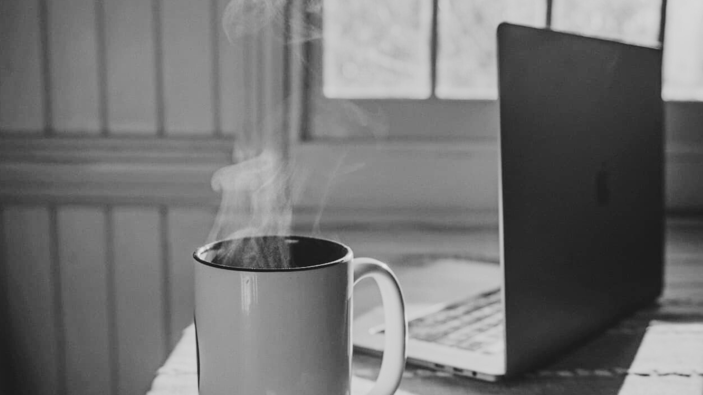 Een laptop met een kop thee.
