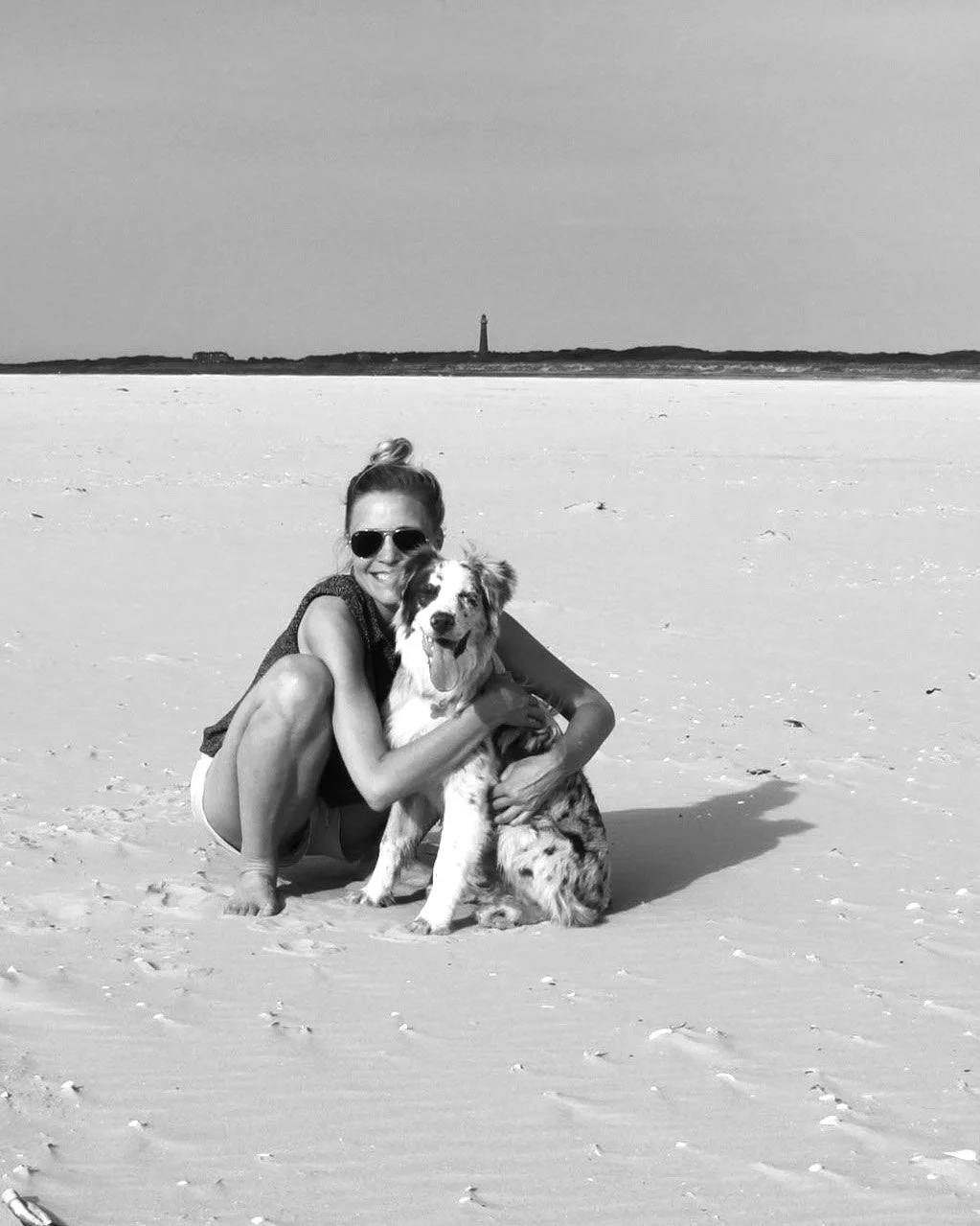 Webdesigner met hond op het strand, zwart-wit portret