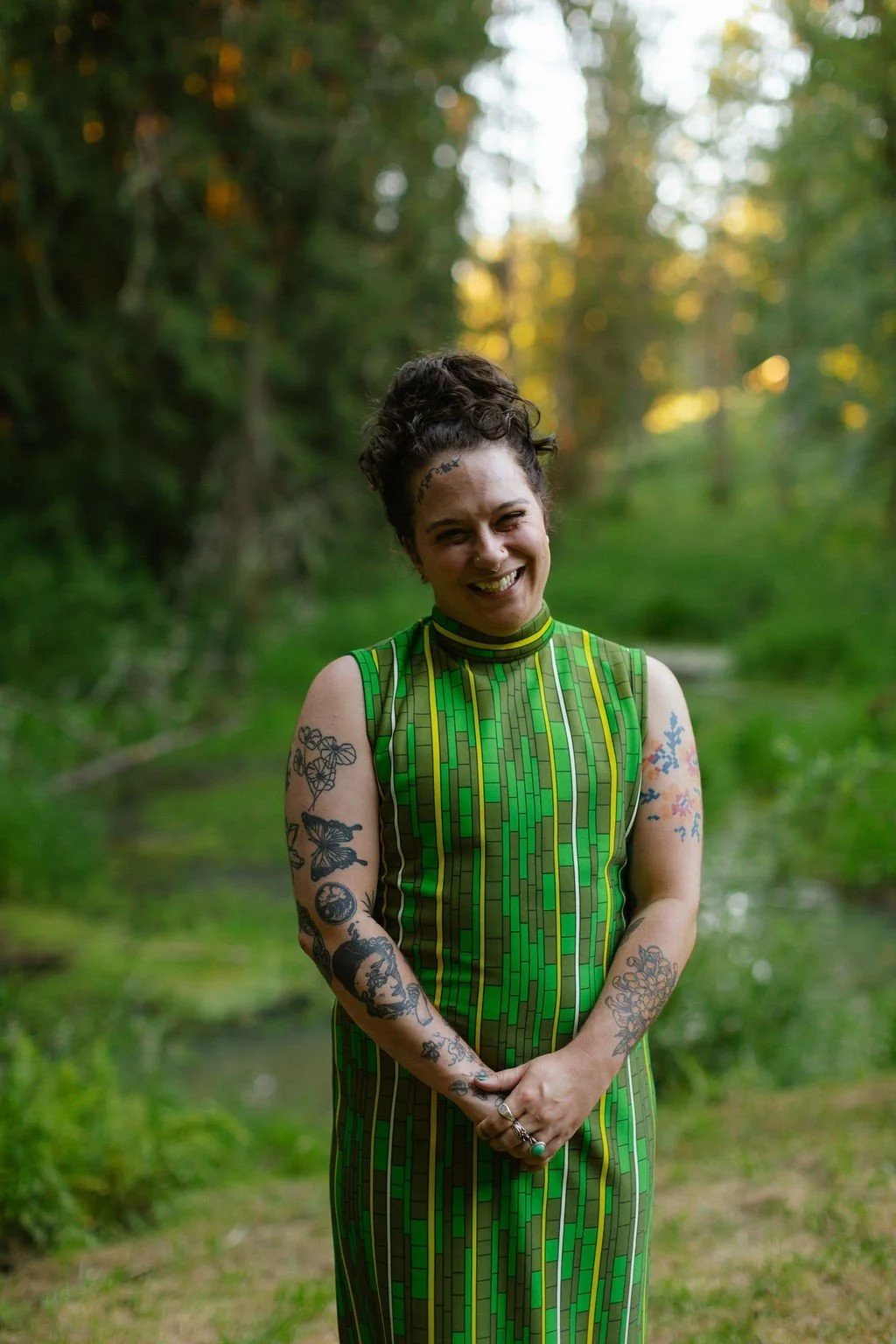 al, a non binary queer speech language pathologist smiling for a picture in nature