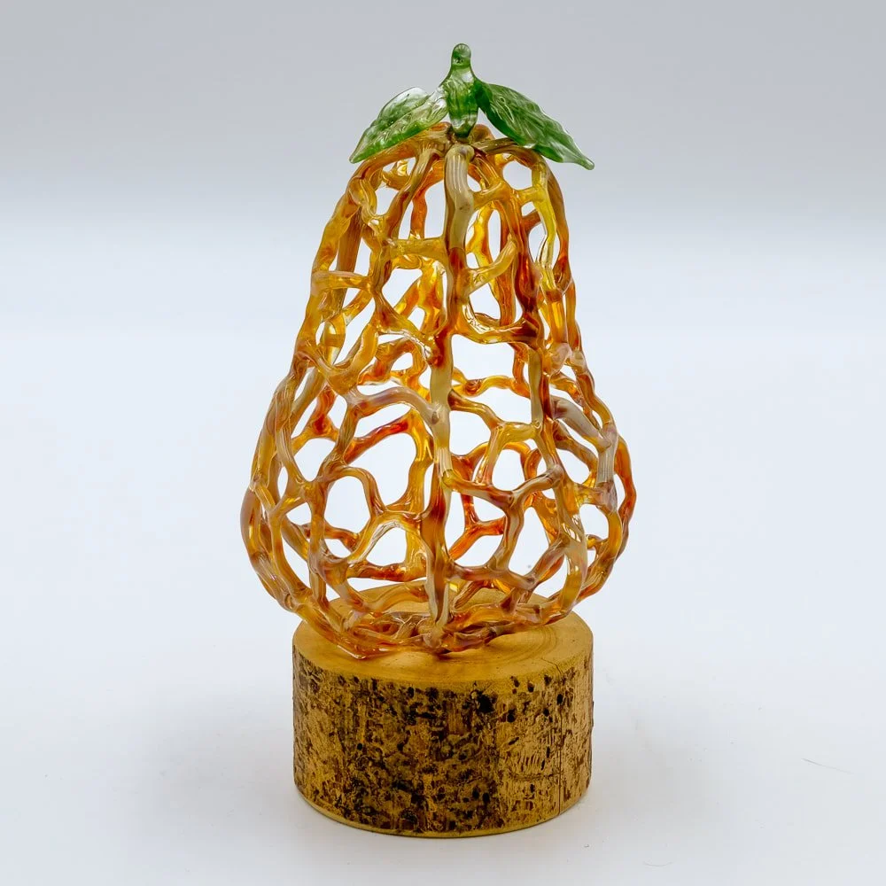 Colorful glass sculpture resembling a pear, mounted on a wooden base.