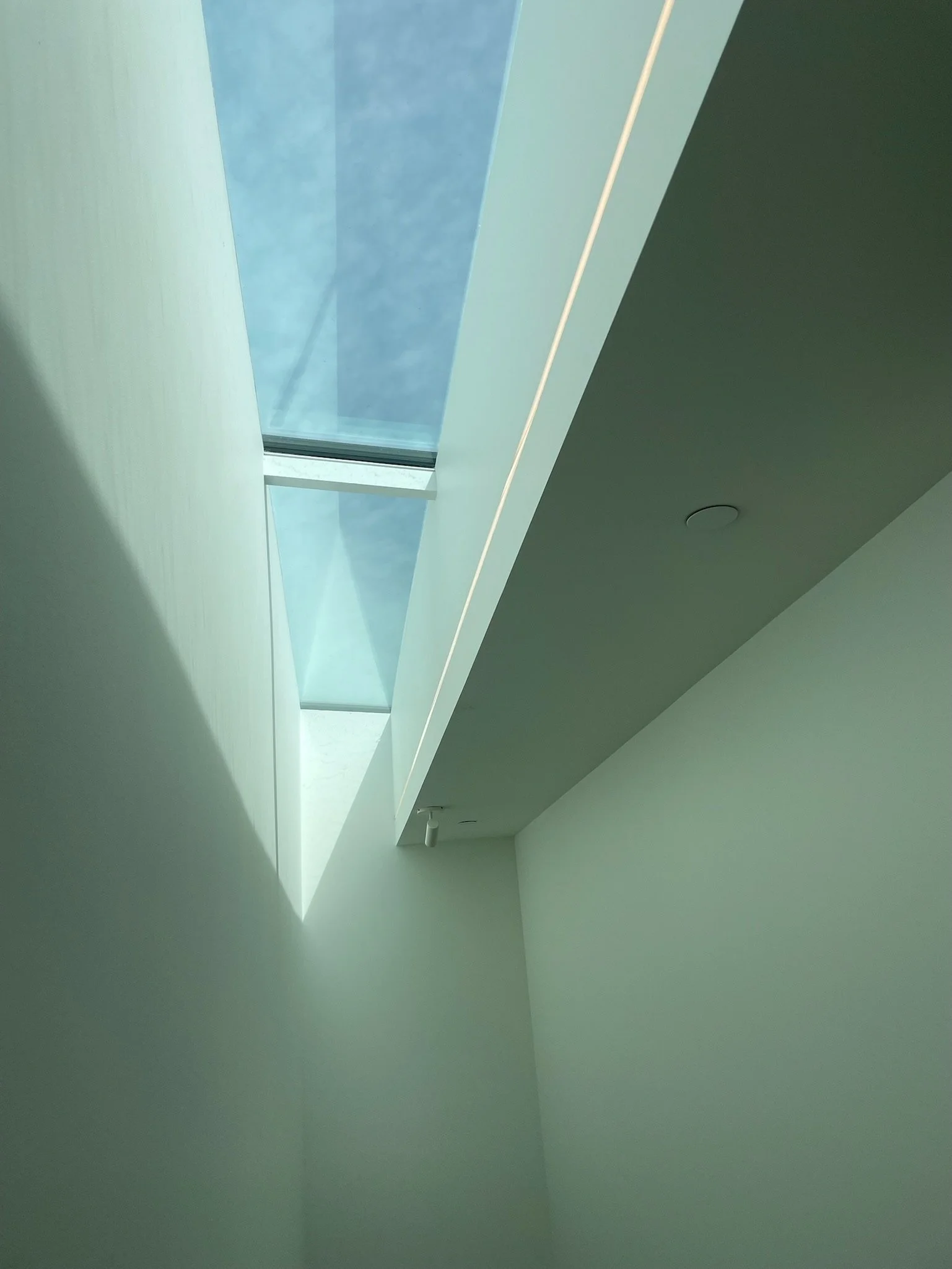 Interior view of a modern building with a large skylight allowing natural light to enter.