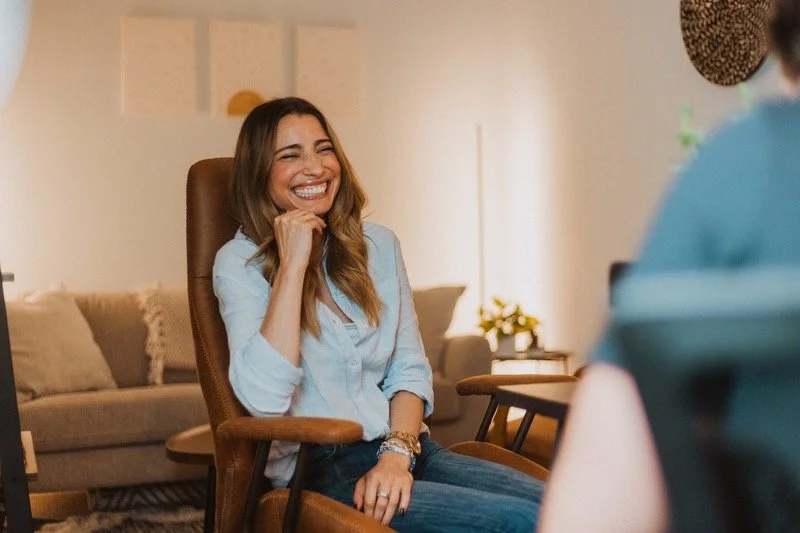 Chloe Miller, Founder of Lovers Counseling, smiling in therapy office.