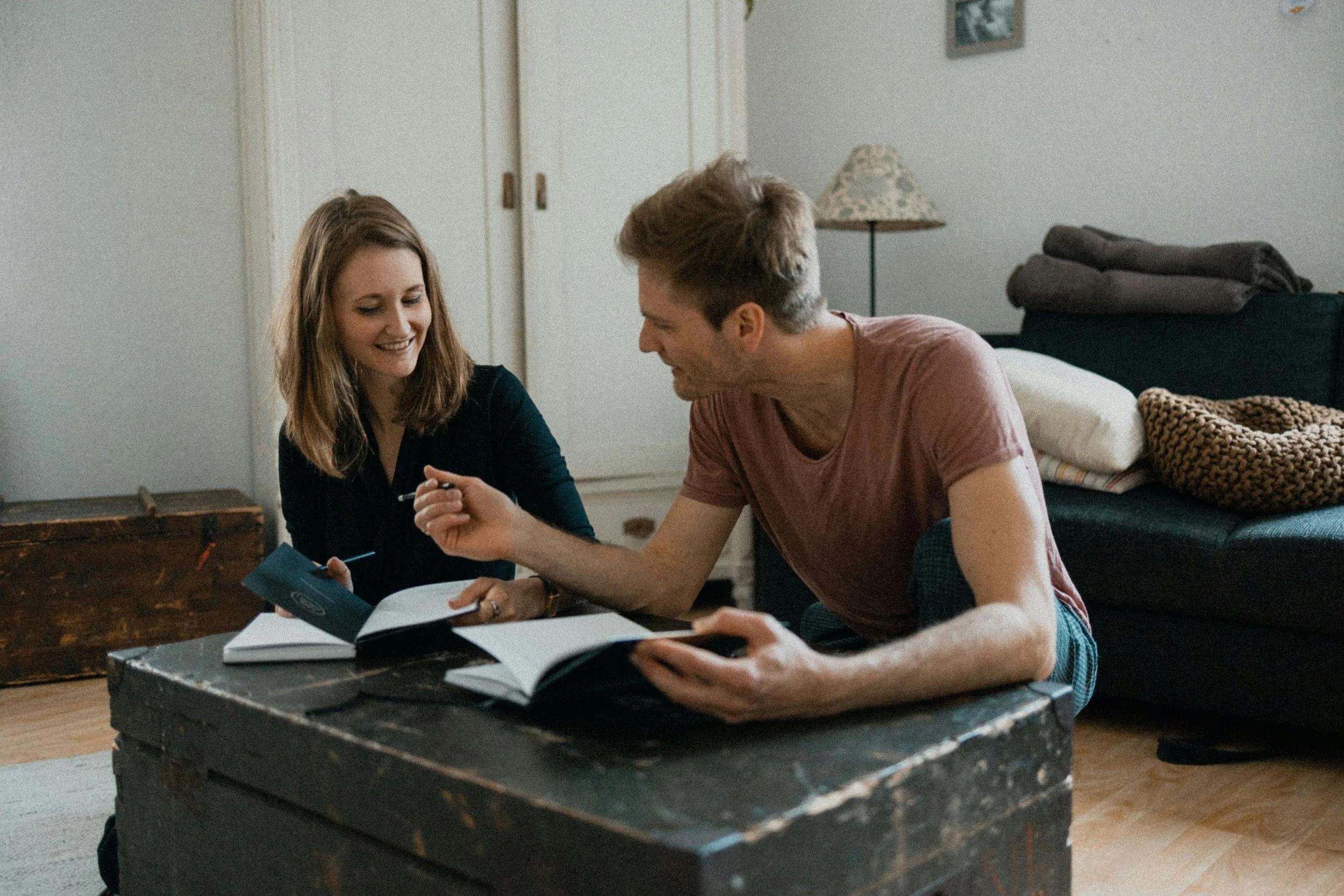 Couple sitting together with notebooks, reflecting together on goals