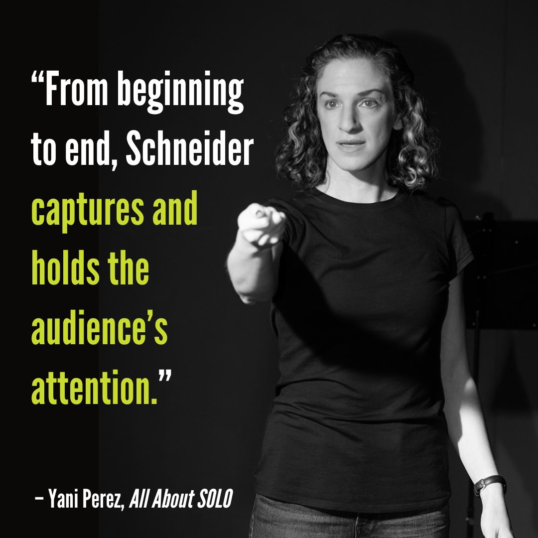 Black and white photo of a woman with curly hair, wearing a black shirt, speaking and pointing forward onstage. Overlaid quote: 'From beginning to end, Schneider captures and holds the audience’s attention.'