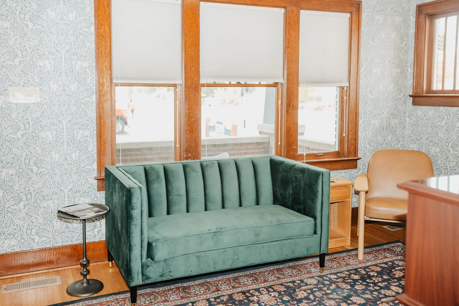 waiting room at Rowe Financial Group. Green couch and tan chair is in the room.