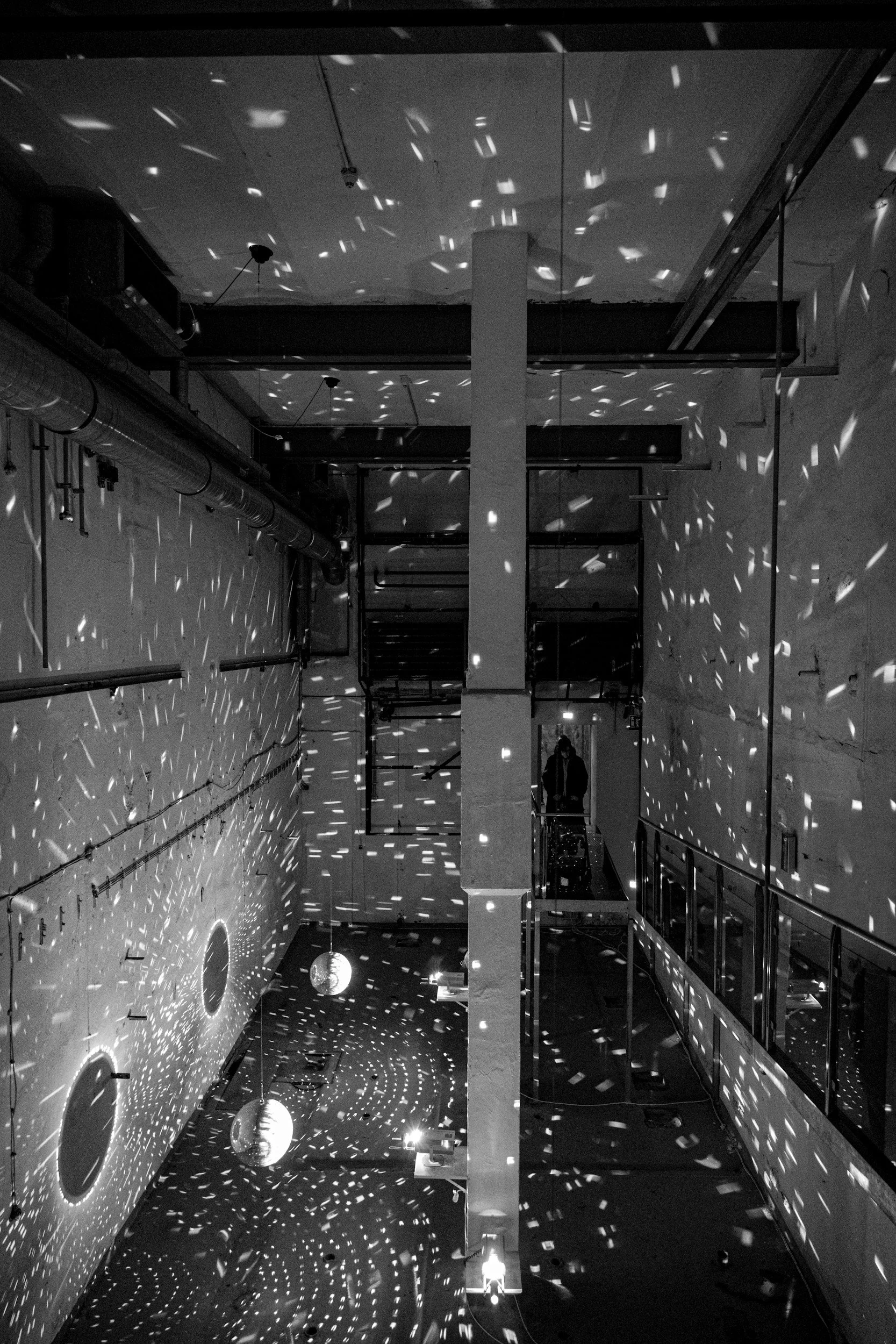 Black and white image of a industrial space with disco ball reflecting dramatically to represent sustainable AV and exhibition advisory.