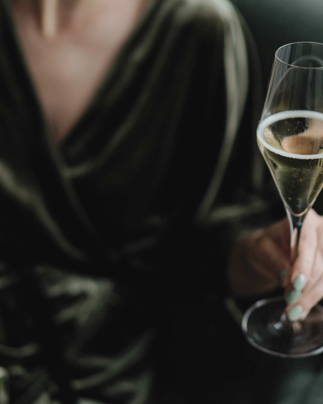 Woman in green velvet evening dress golding champagne glass. This represents the luxury hospitality, events and venues Carbon Literacy training the consultancy offers.