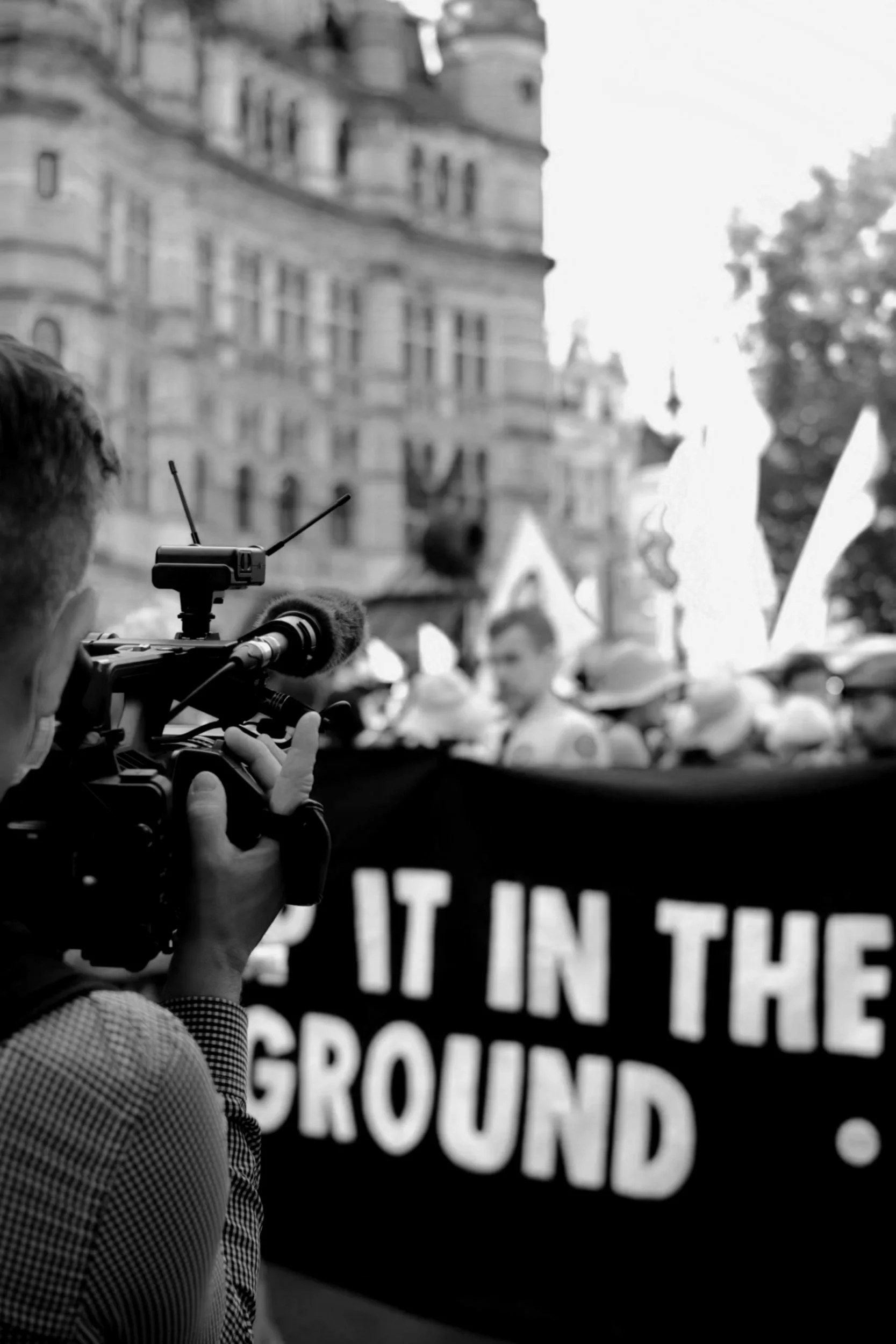 Black and white image if a camera person documenting an environmental protest outside a museum. This represents the sponsorship and reputational advisory the consultancy offers.