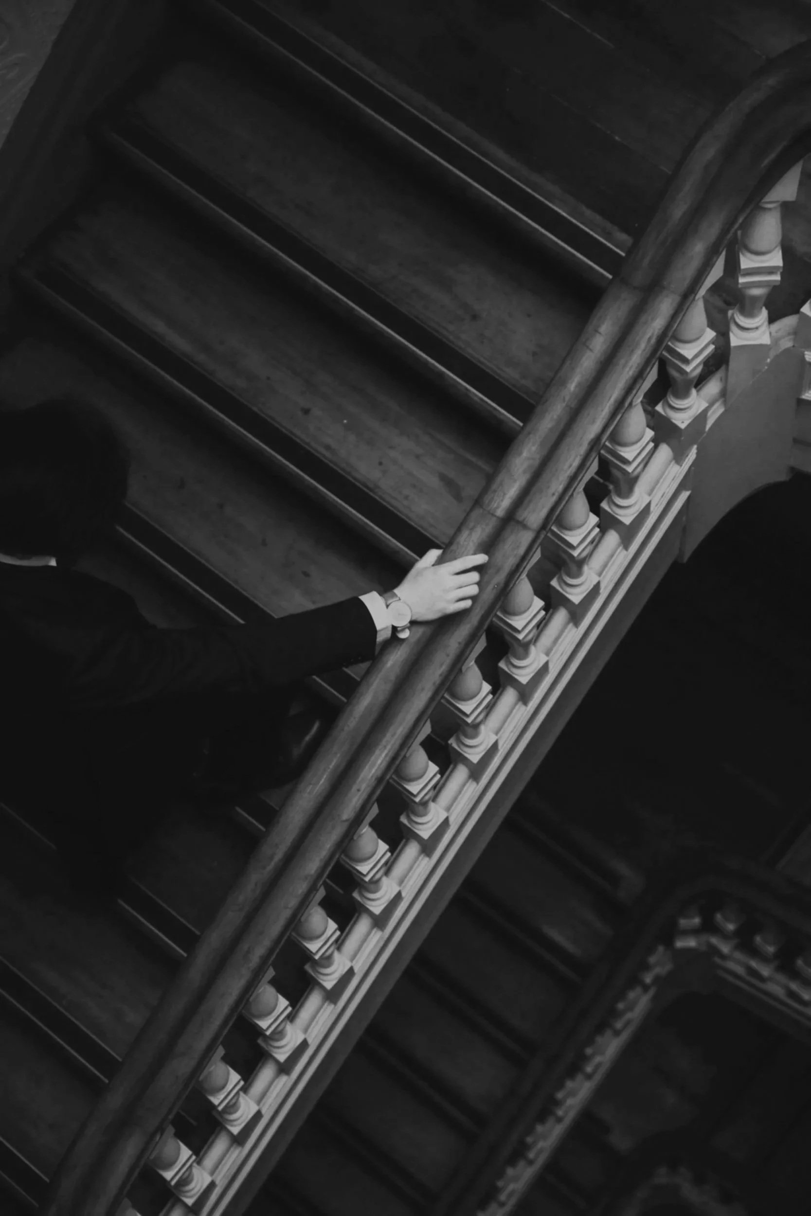 Man in elegant evening attire ascending a wooden staircase. This represents the luxury catering, events and hospitality industries the consultancy serves.