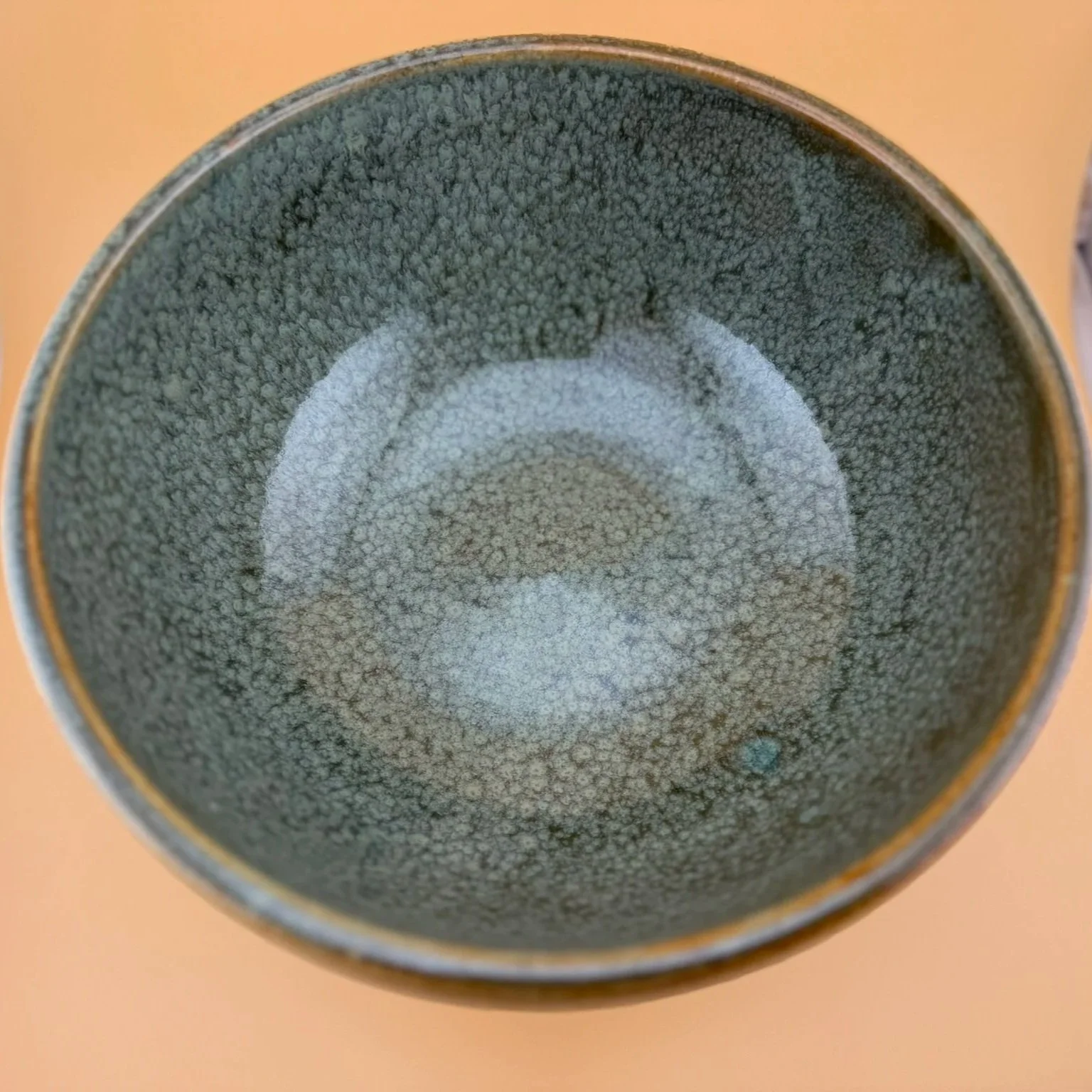 Close-up view of a ceramic cup with a textured, speckled interior surface.