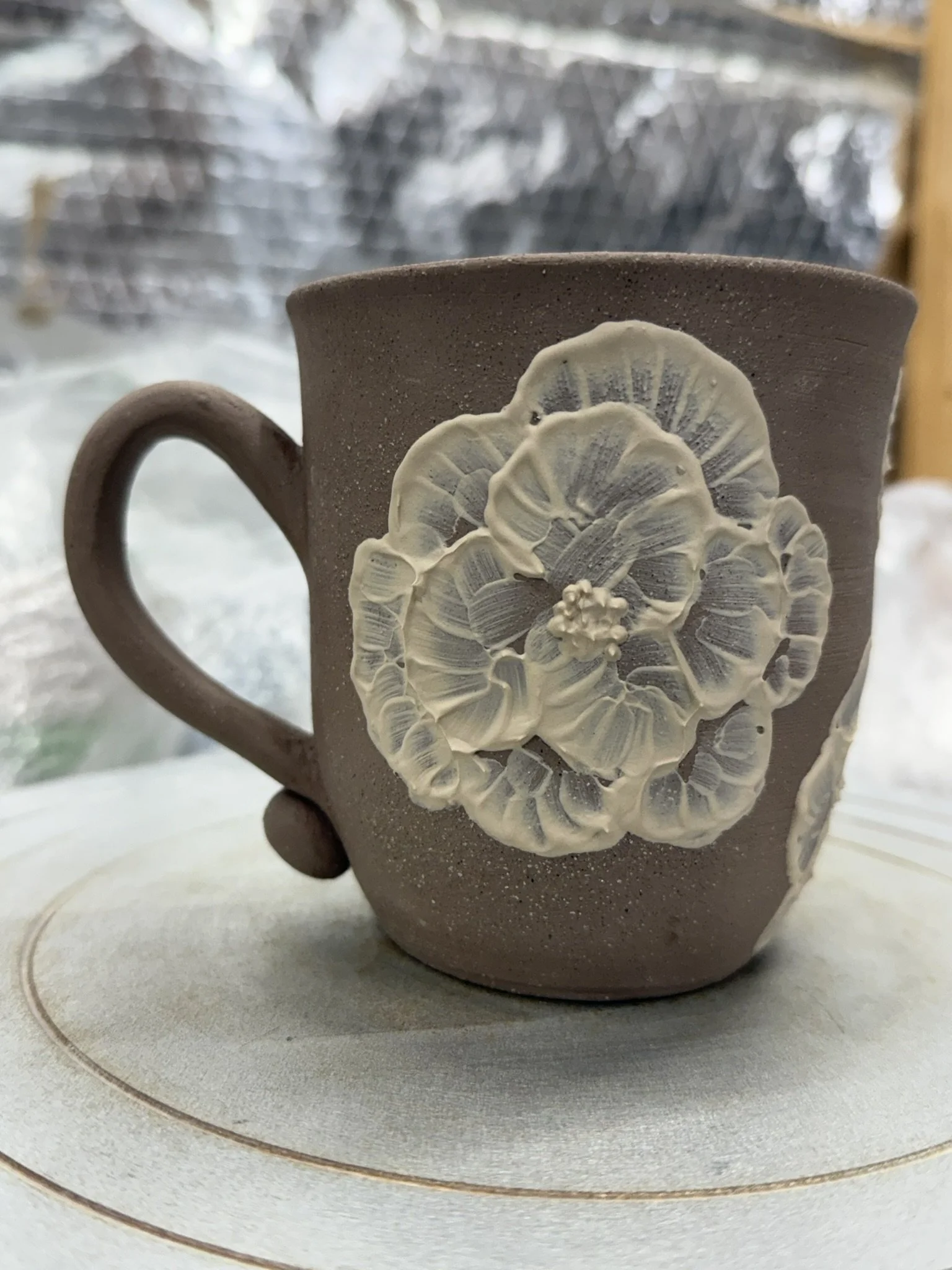 Mug with slip flowers.