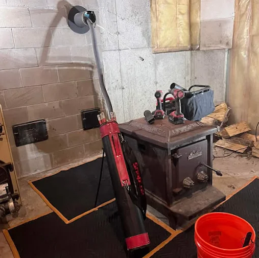 A nearby workbench with a container of wooden blocks, a drill, and various tools, with a red telescope in the foreground.