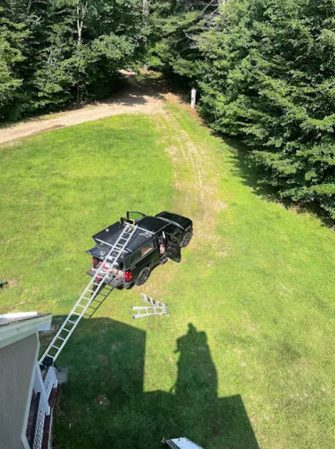 Granite State Chimney truck on grass with long ladder hanging off the back