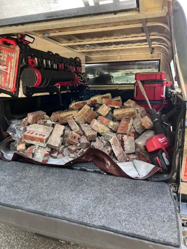 Truck bed filled with removed brick and masonry debris from chimney repair project, highlighting professional chimney repair and restoration services by Granite State Chimney.