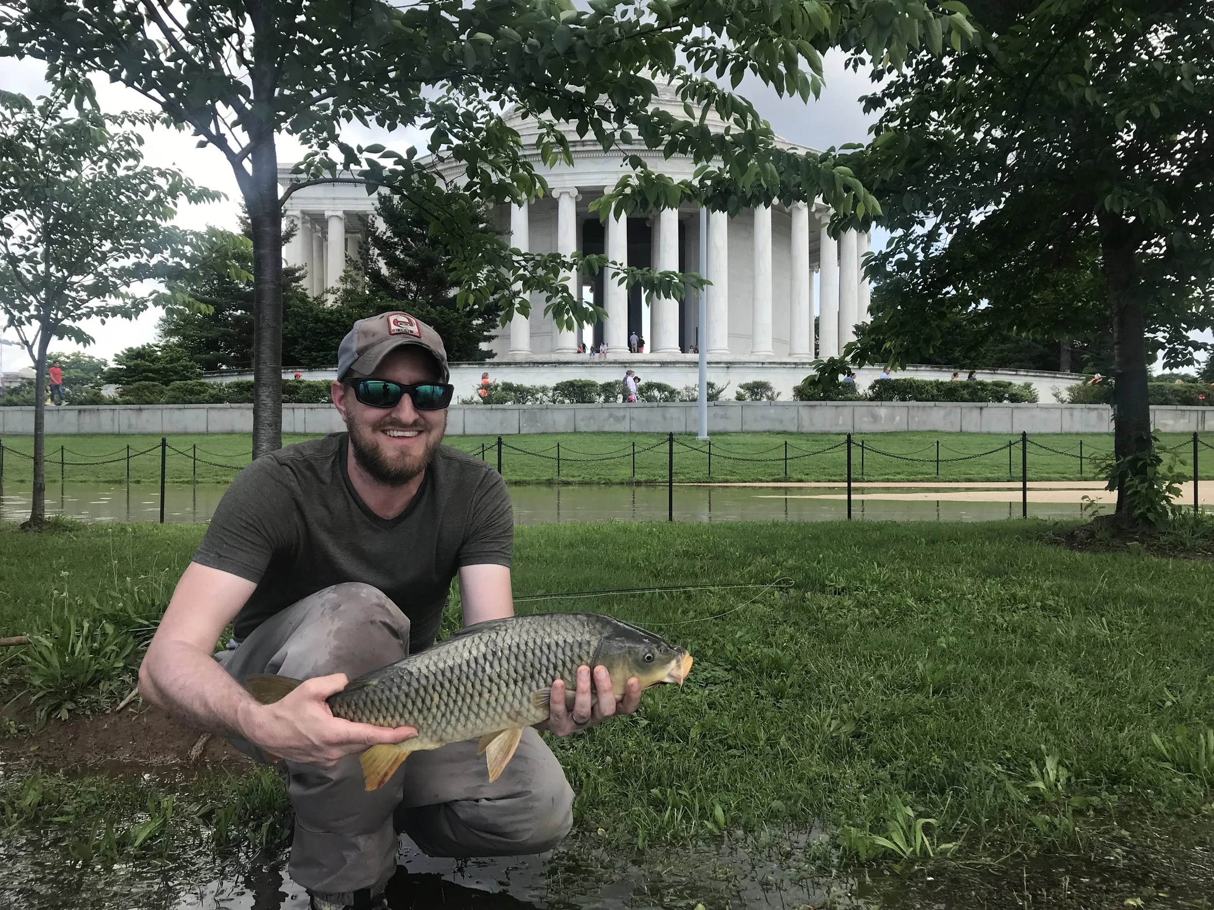 Jason Reif with a fly caught carp in front of the Jefferson memorial 