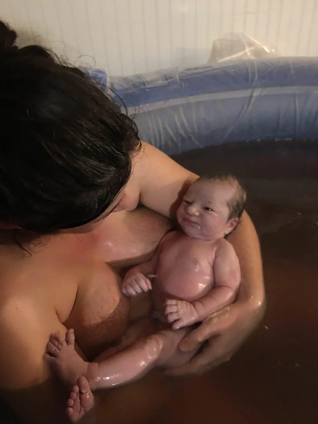 close up of baby in water after home birth phone photo
