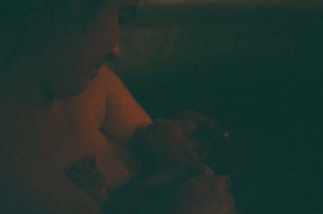 film image dark of mother holding newborn in homebirth