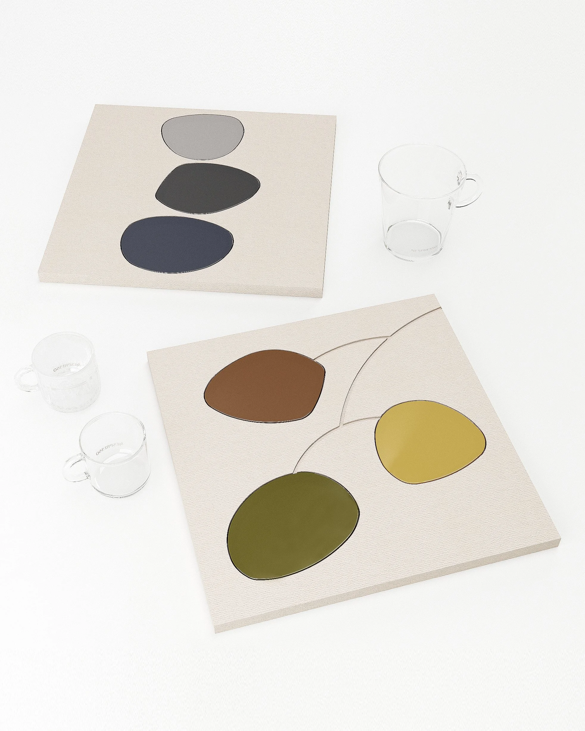 The coasters are packaged in environmentally friendly recycled paper trays that display pictures of stacked pebbles and a balanced mobile represents the overall concept.