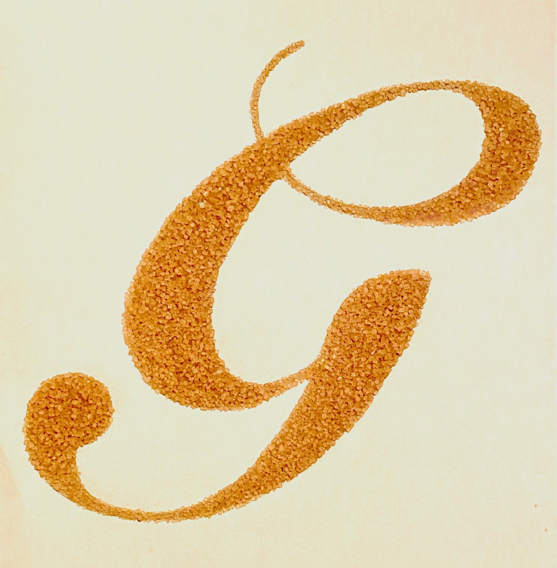 Letters and numbers formed using paper bits, yellow split peas, and turbinado sugar.