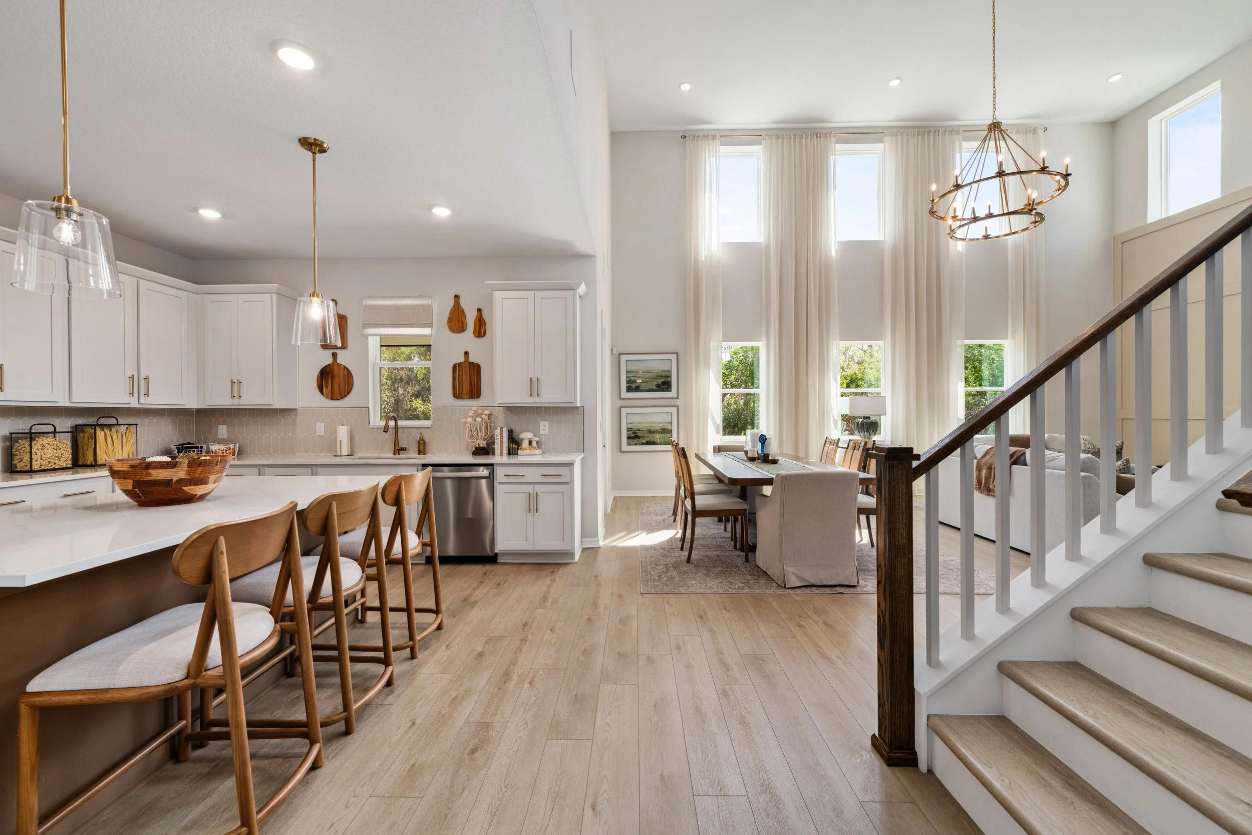 Modern kitchen with white cabinets, stainless steel appliances, a marble backsplash, and a black kitchen island with a sink.