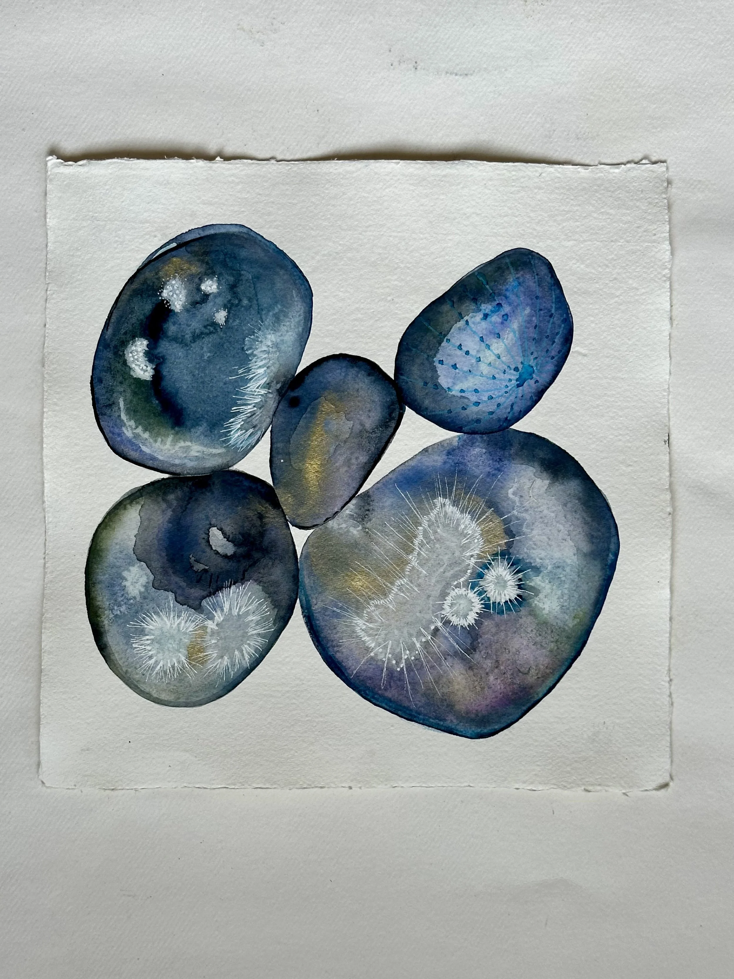 Abstract watercolor painting of five blue and gray oval shapes with textured patterns on white paper.