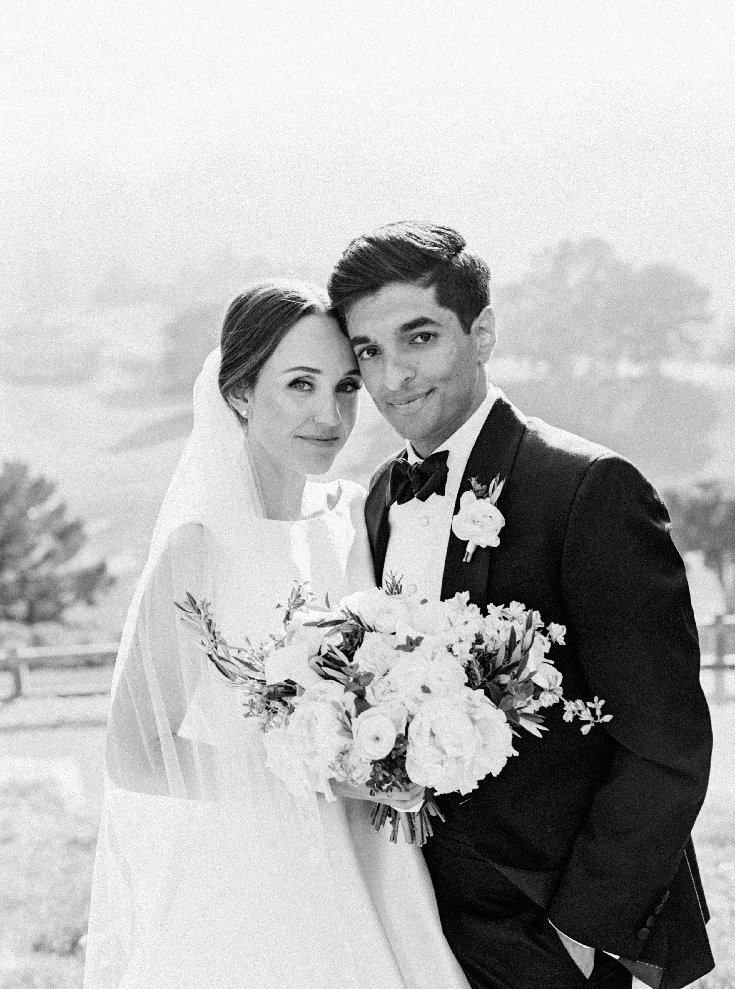 Wedding portrait of a bride and groom, bride holding a bouquet.