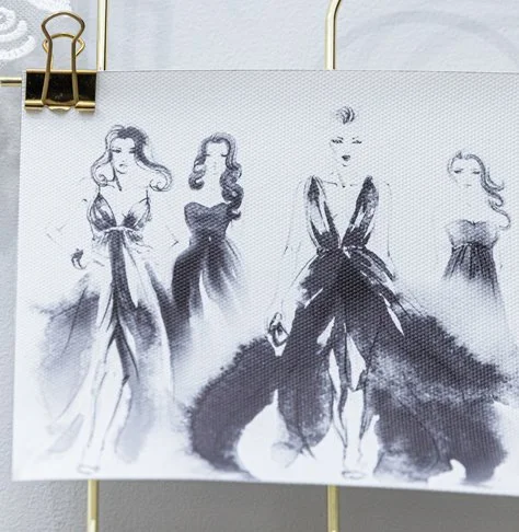 Four fashion sketches of women in elegant dresses, drawn in black ink with loose, flowing lines, on a white background.