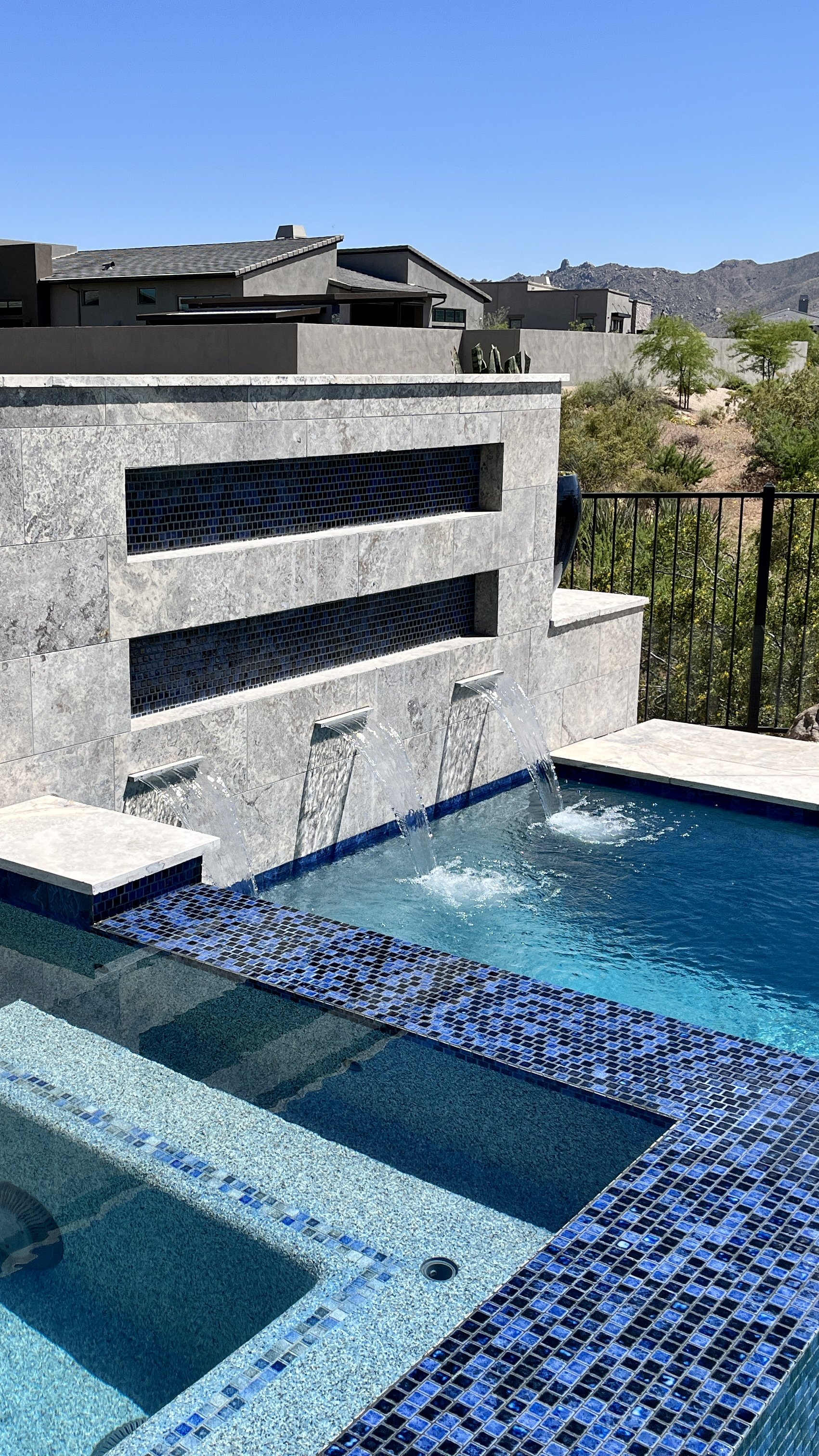 water feature over pool spa blue 1x1 tiles travertine