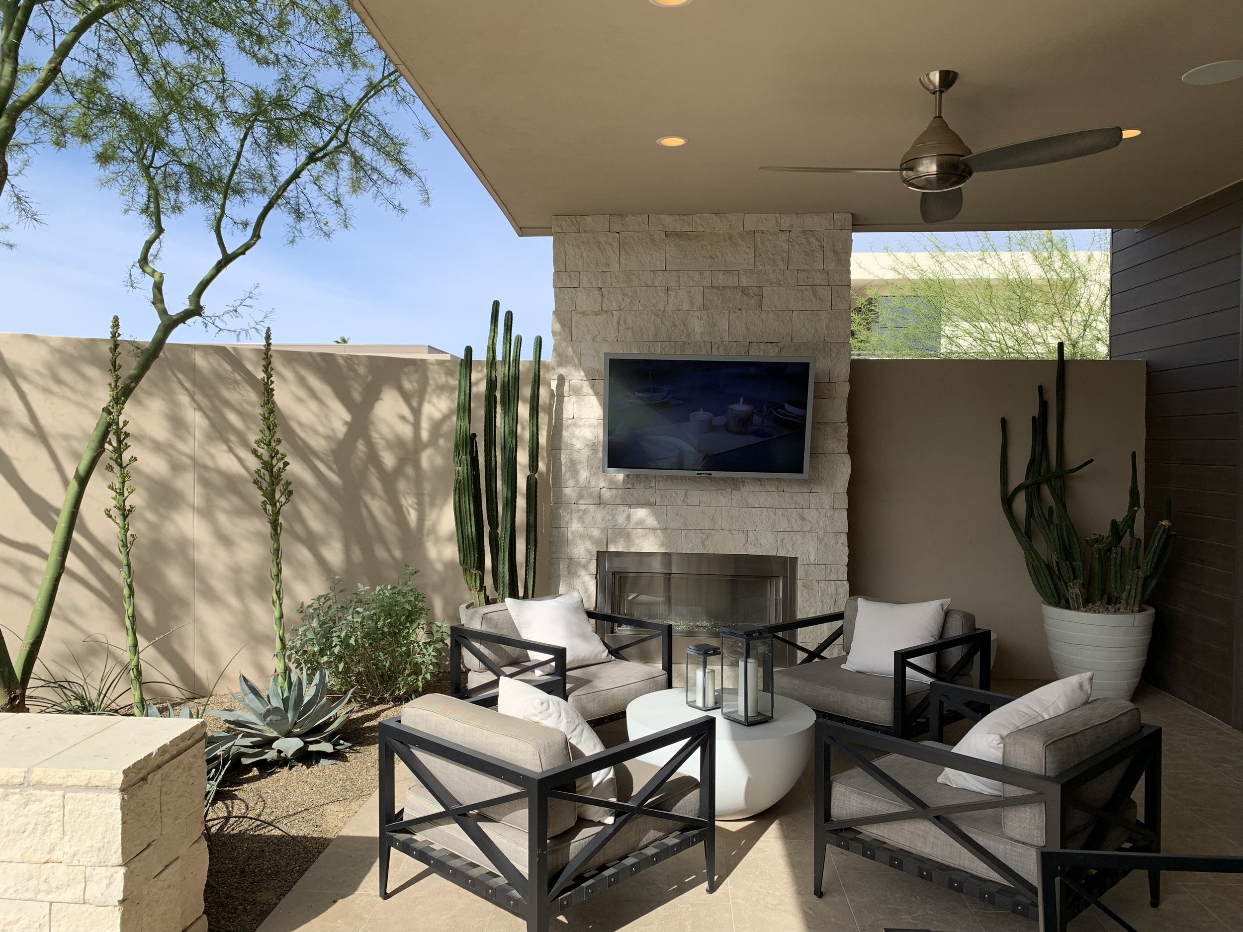 outdoor fireplace cozy sitting area tv cacti pots