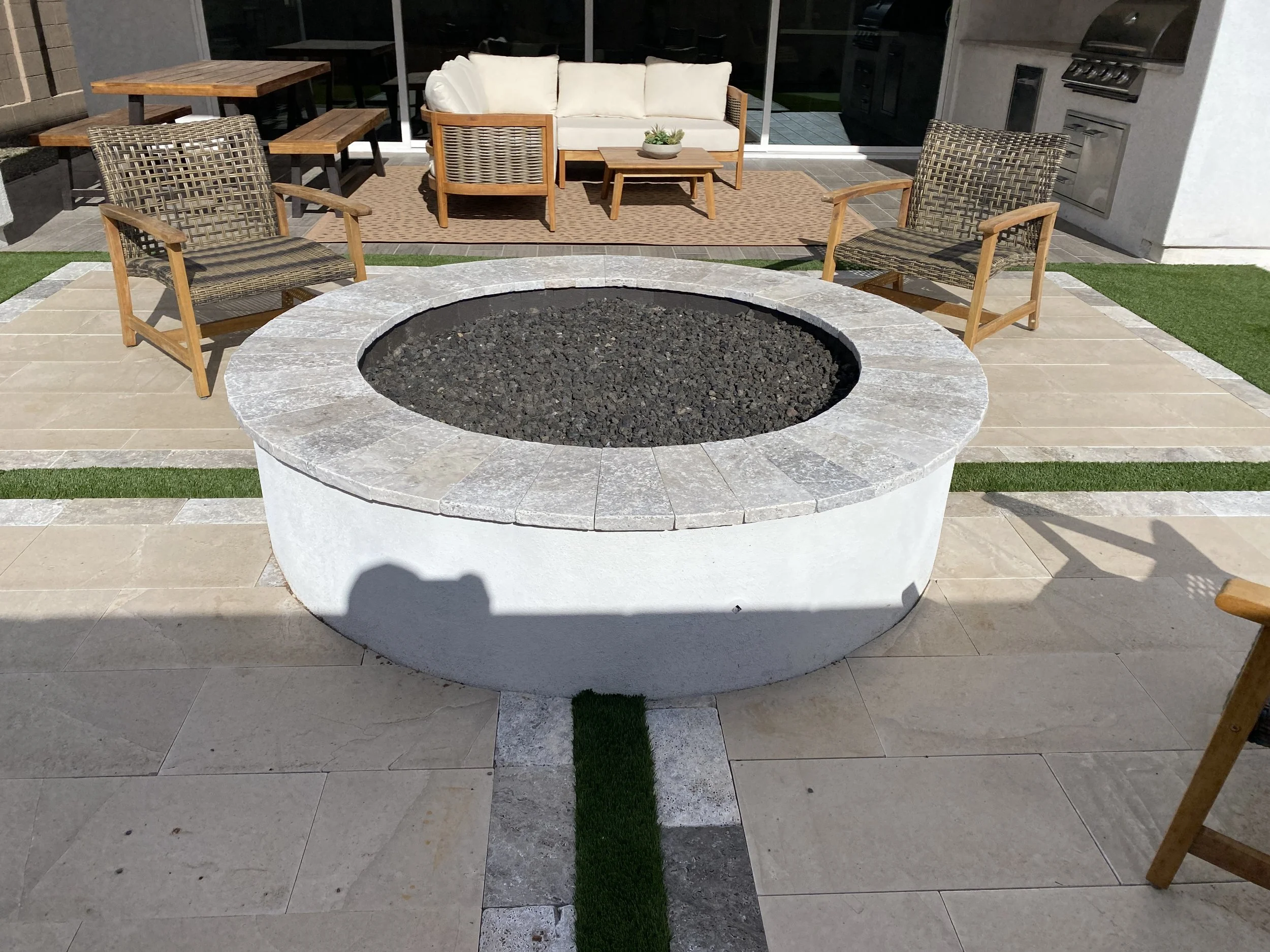 large round fire pit feature lava rock travertine seating area