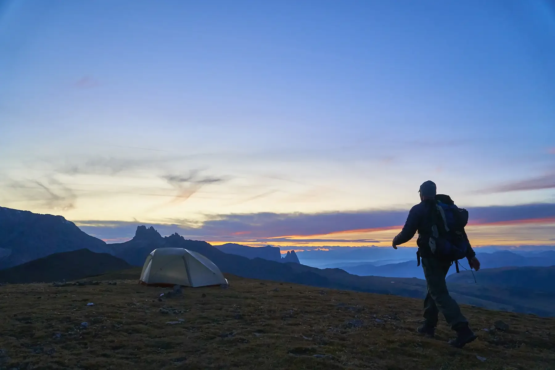 hiker-walking-to-tent.webp