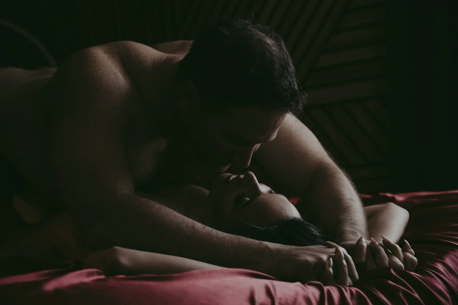 A man and woman posing on a bed during a couples boudoir photography session in Edmonton