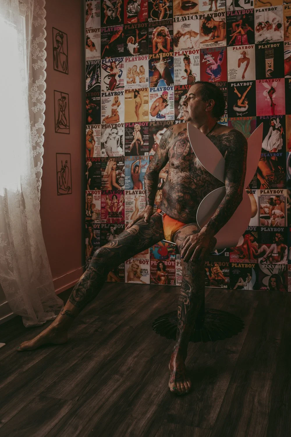 A man sitting on a play boy chair posing during a male boudoir photography session in Edmonton