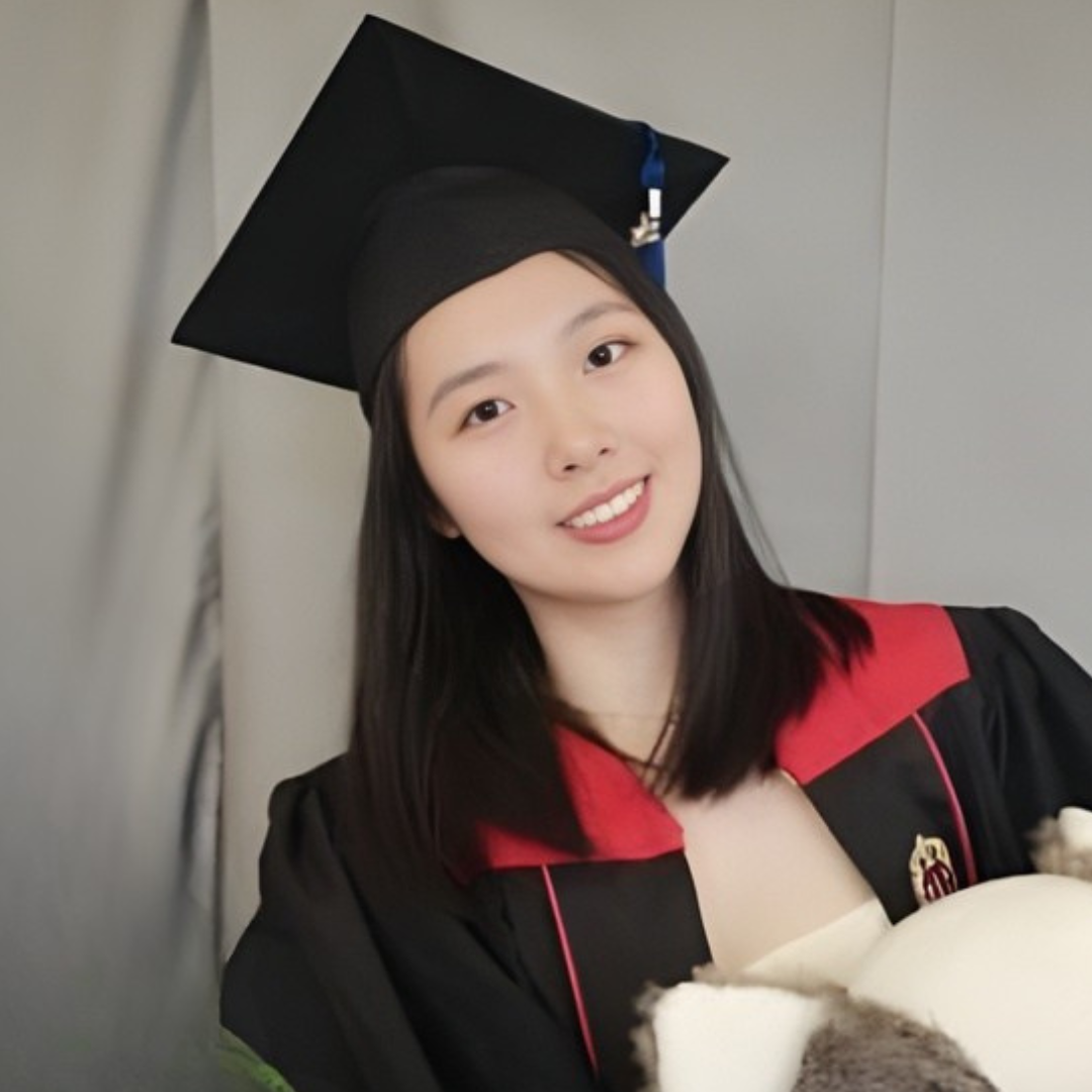 Young woman in a graduation cap and gown smiling at the camera.