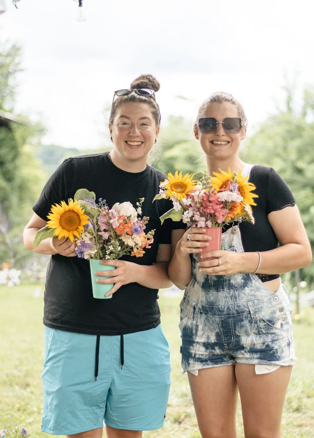 U-Pick Flowers guests holding their cups full of cut flowers for the camera.