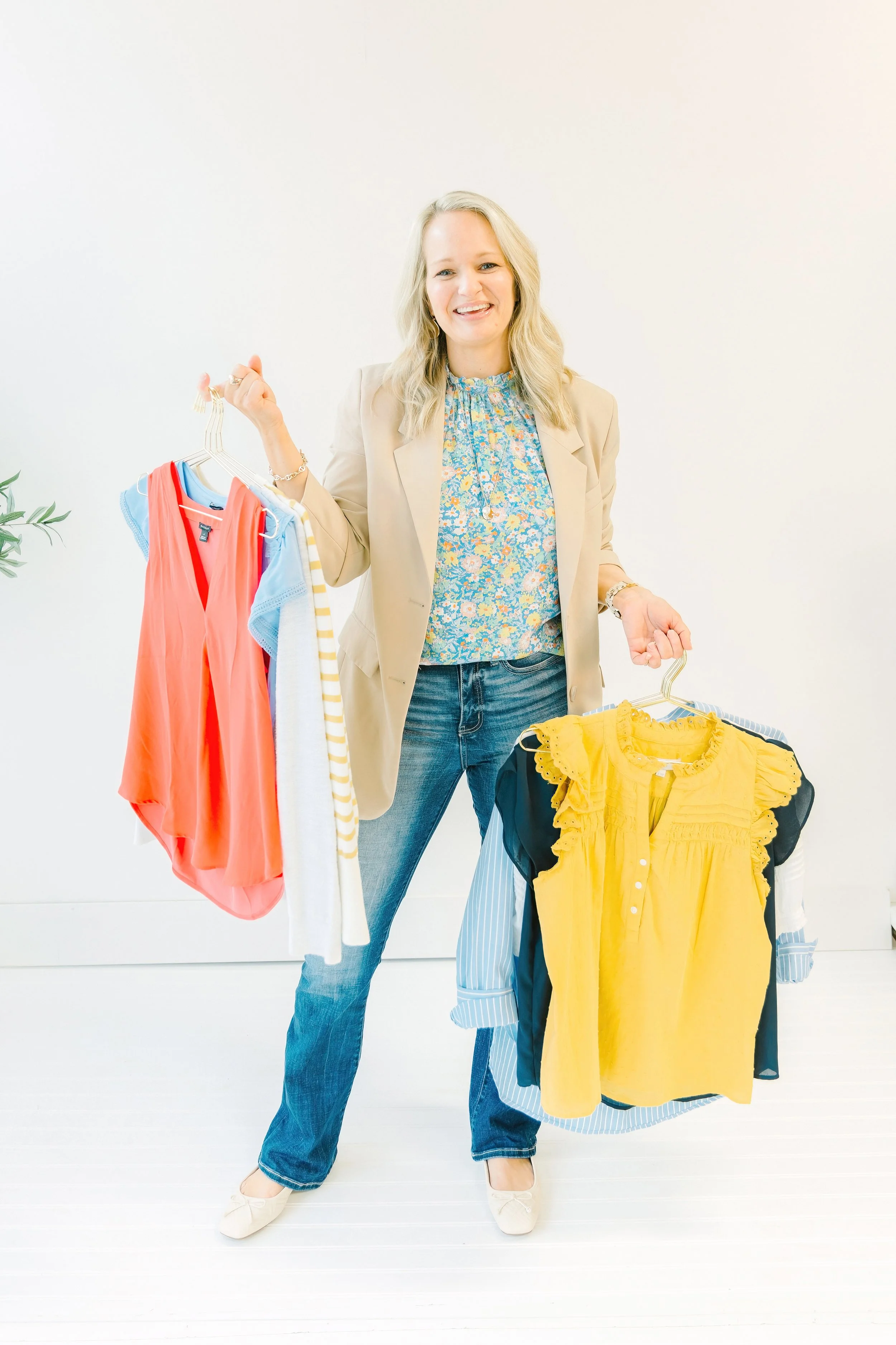 Long Longmire stands with a number of articles of clothing ready to help you as a personal wardrobe stylist in San Antonio.