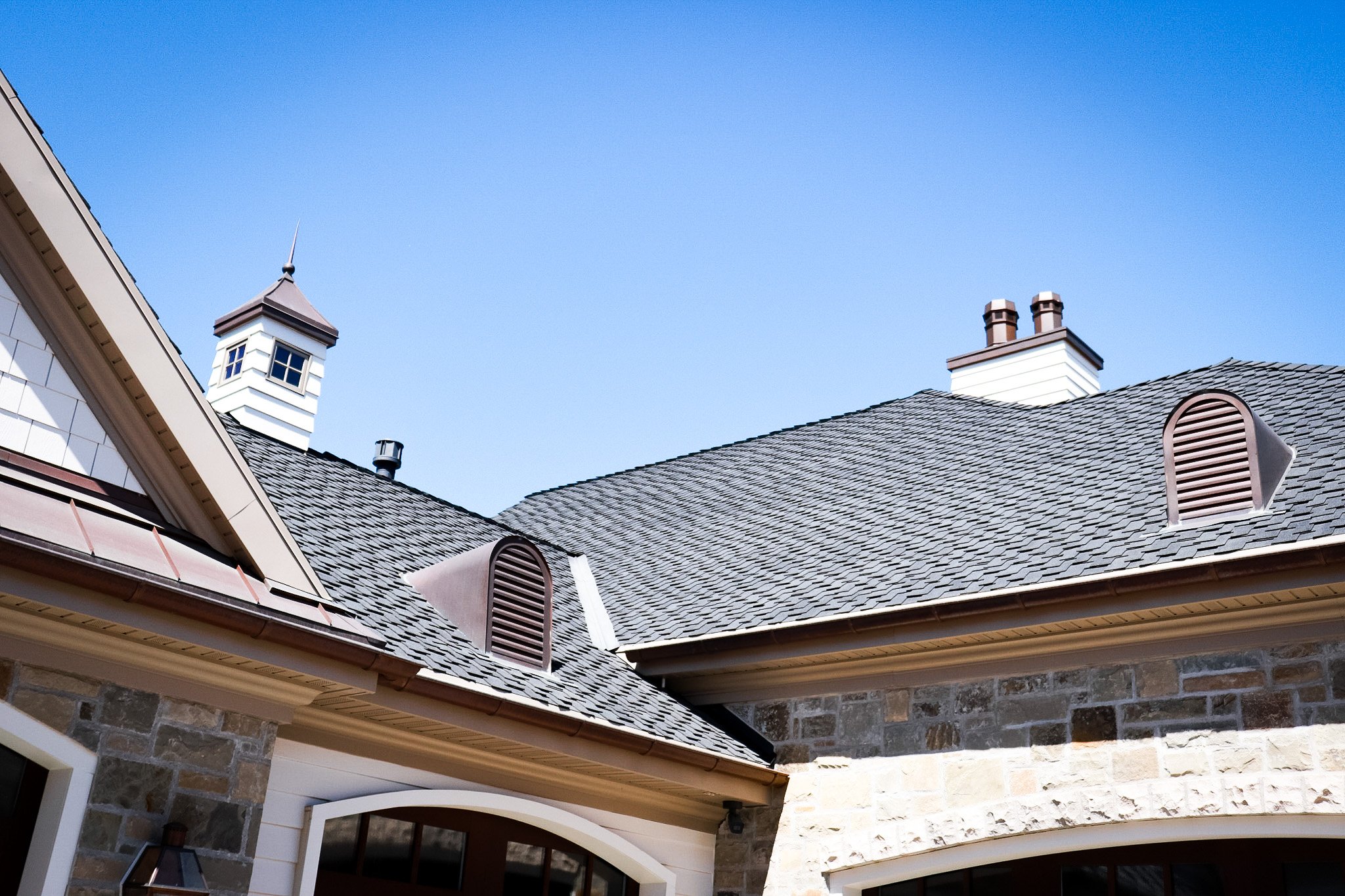 Custom siding with copper cupla, chimney pots, & roof louvers.