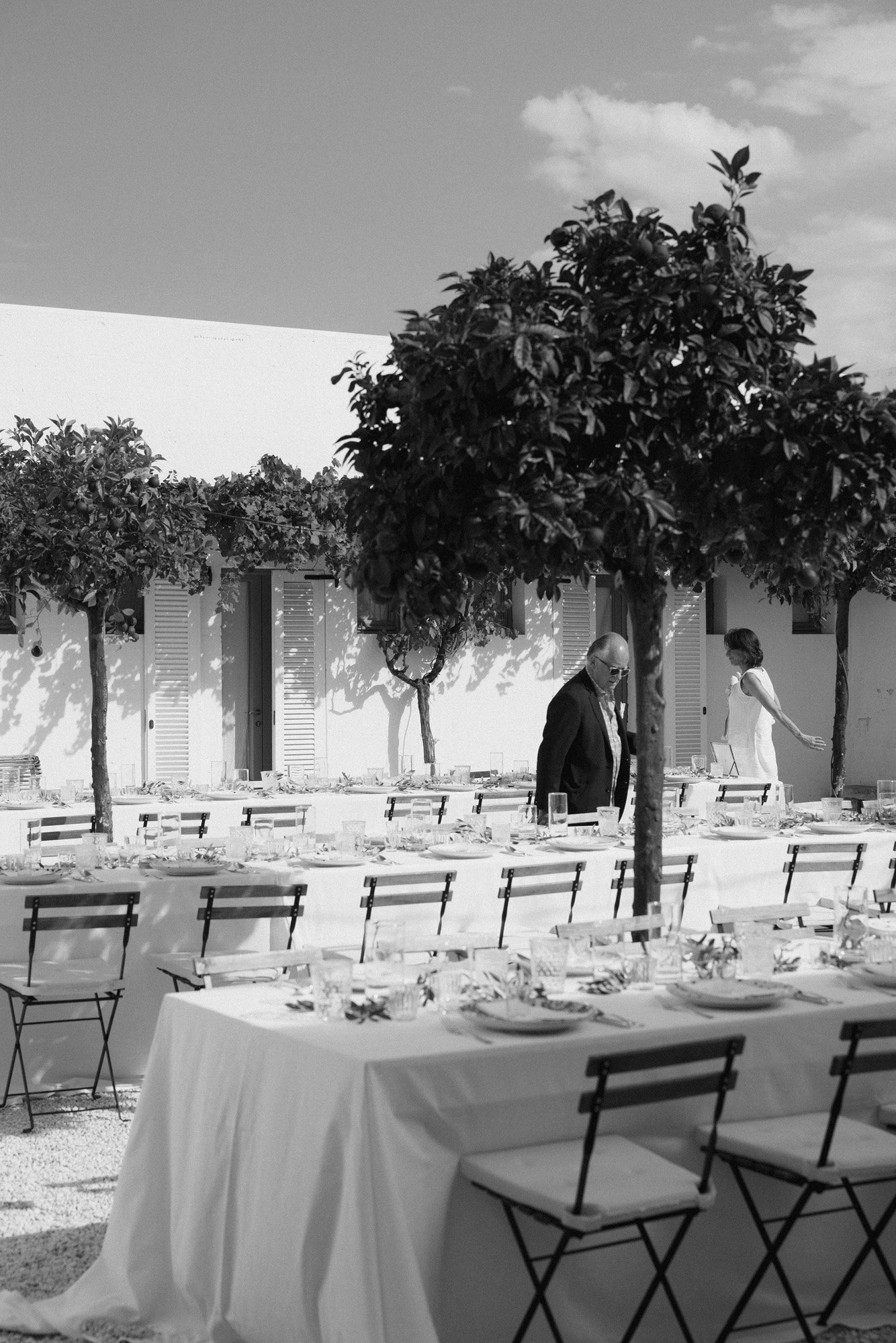  a chic and modern wedding reception in italy with olive trees and folding chairs in an effortless black and white photo. 