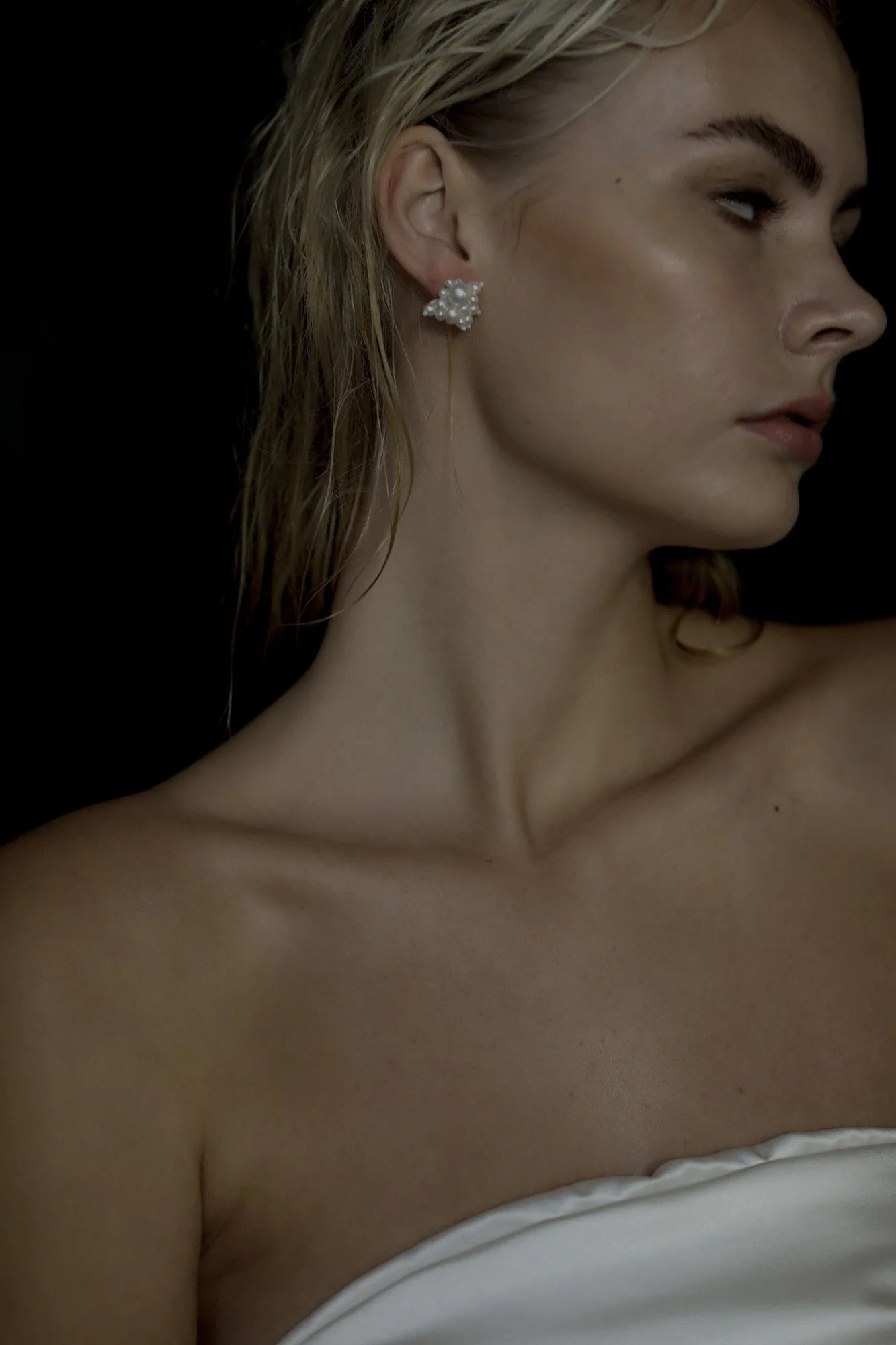 Image of model wearing stud earrings with varying sized ivory pearls. (Copy)
