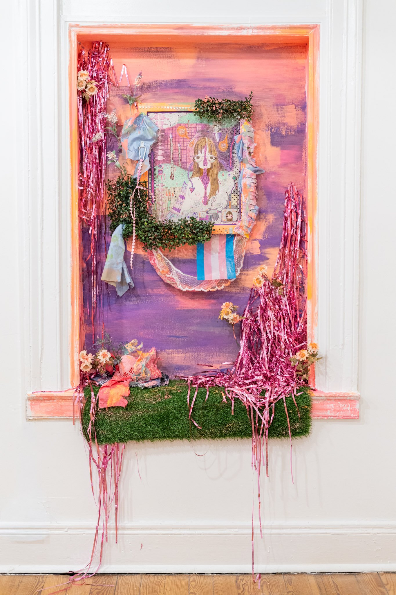 Morgan Hardigree: As the World Folds Inward, how will the Wizards stop the meteor?, 2025. Color pencil on paper, wire flowers, ribbon, plastic wrapping, fake foliage, fabric, carabiner, frame with acrylic paint; 32 x 24 inches.

[Surrounding installa