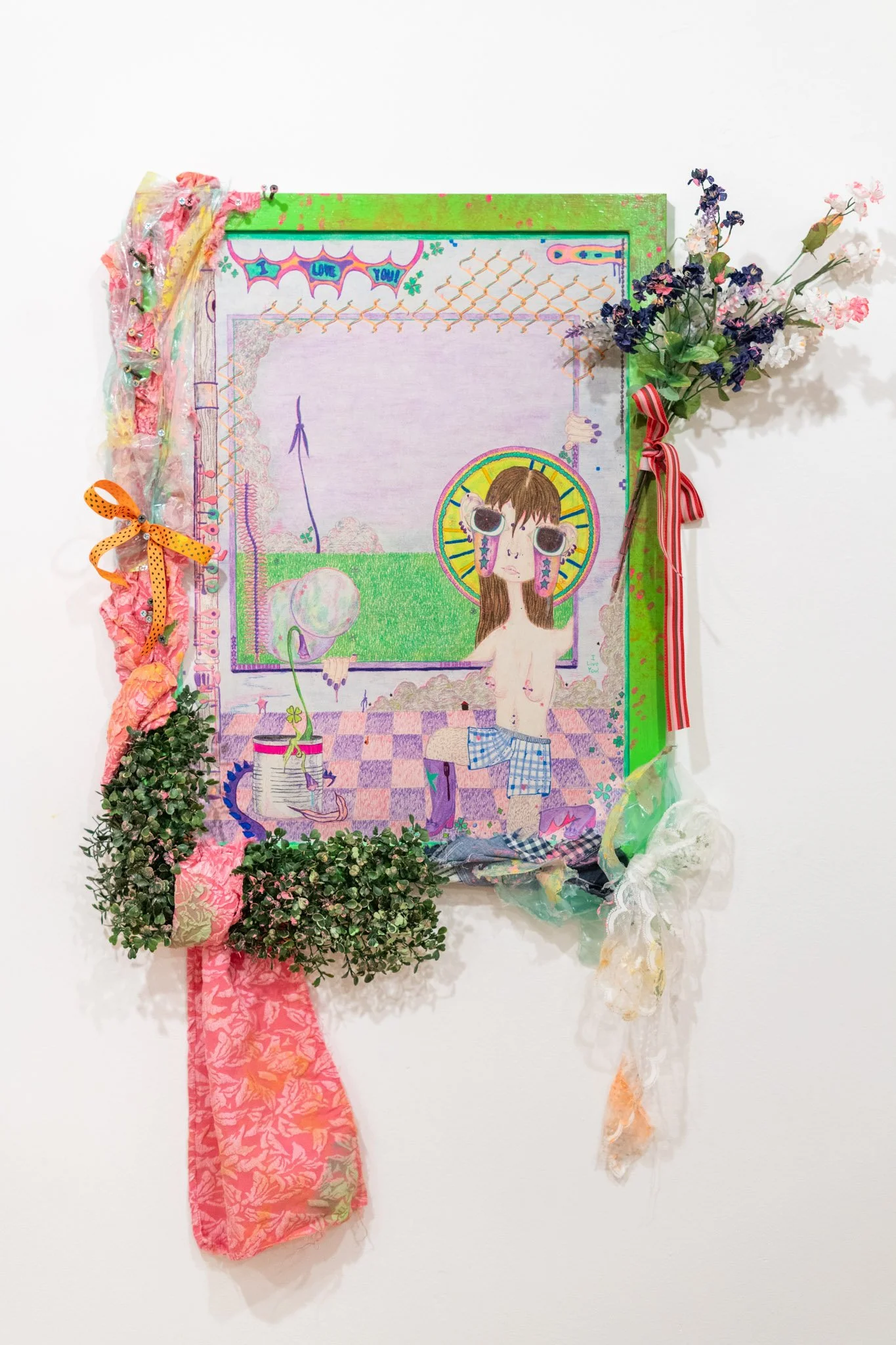Morgan Hardigree: Flute Girl, 2025. Color pencil on paper, wire flowers, ribbon, plastic wrapping, fake foliage, fabric, frame with acrylic paint; 40 x 29 inches. 