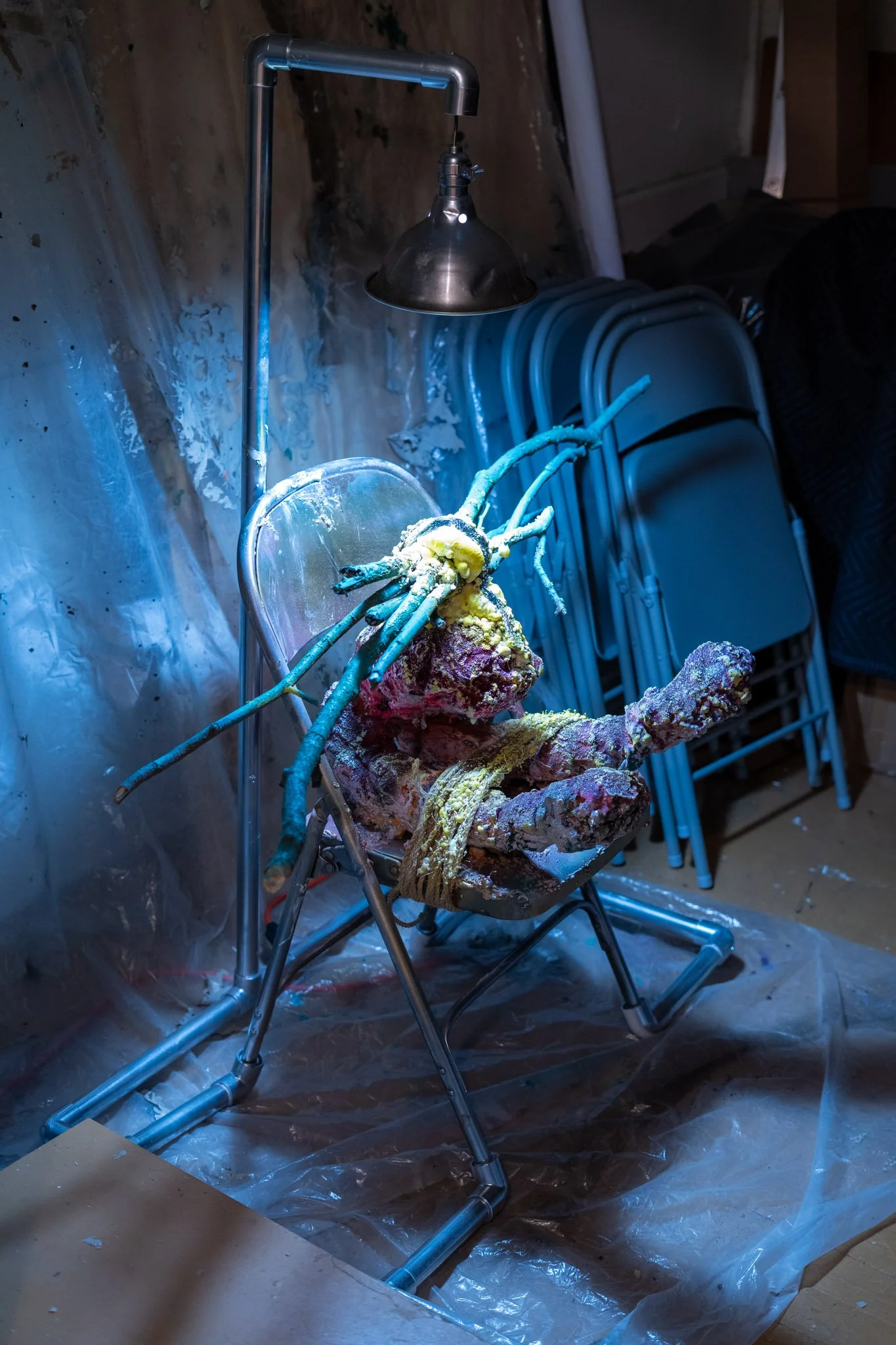 Jason Kash: Alpha, 2025. Mixed media, found objects, belt, sticks, PVC, and light bulb.